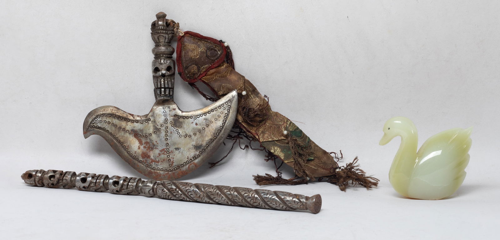 Chinese Jade/ Stone, Tibetan Metal Pieces: Including a stone carved goose sculpture, and two Tibetan metal cast pieces, one of axe form and the other carved with skulls. Approx. 11 inch L (longest).
