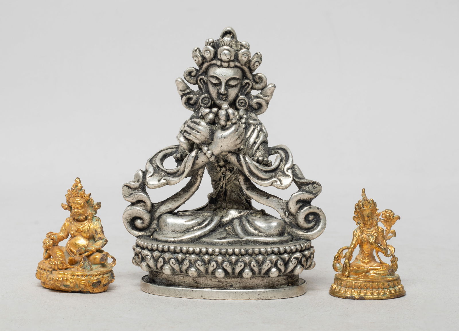 Estate Chinese/ Nepal Sculptures of Buddha: Three Chinese / Nepali Buddha sculptures, each cast seated on a lotus base, the hands in elegant mudra or holding implements, decorated with elaborate diadema. Approx. 3.15*2.45*1.47 inch (largest).