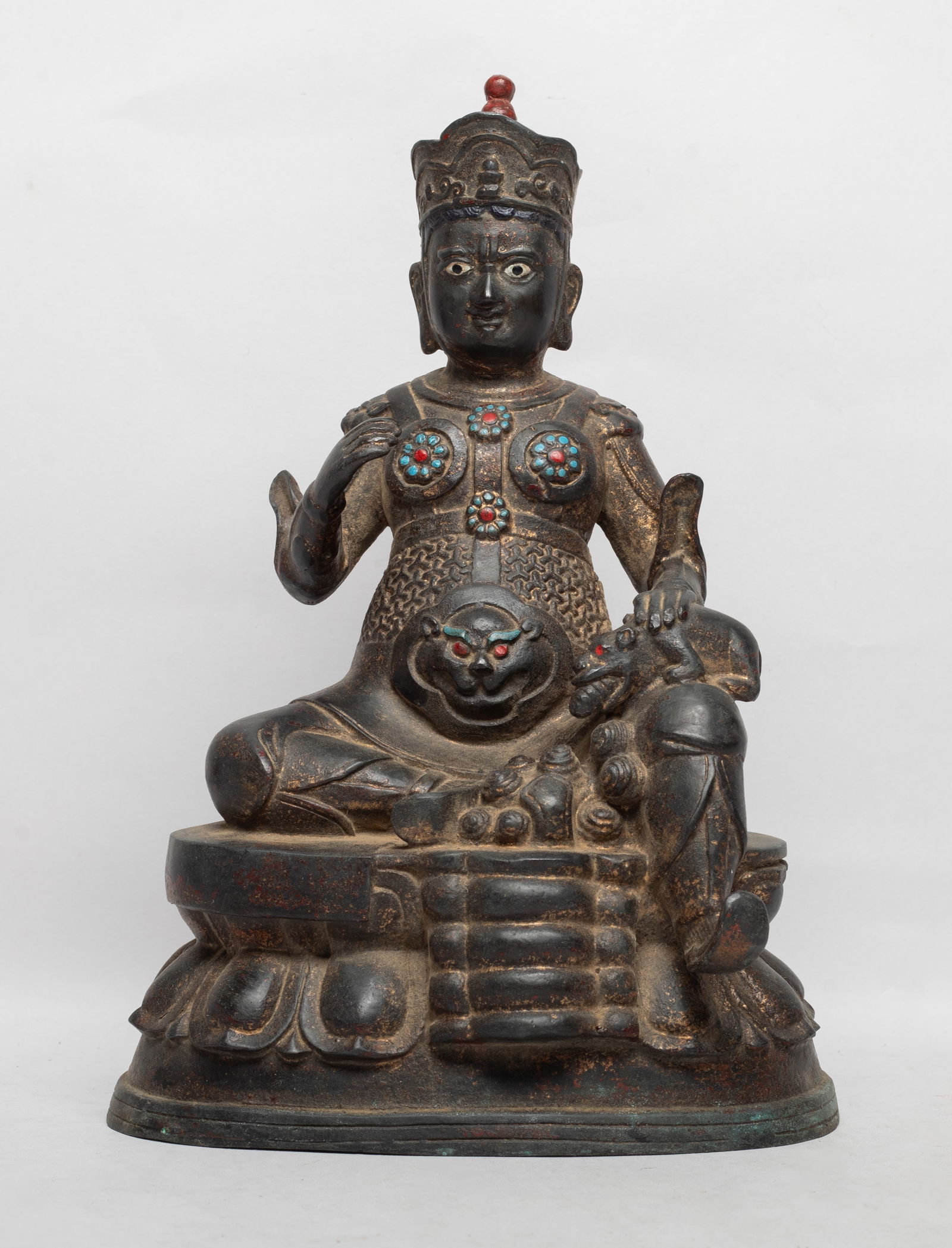 Chinese Sino-Tibetan Bronze Buddha: The Buddha cast seated on a lotus base, the left hand resting on a mouse on left knee, right hand in unknown mudra, wearing a coat decorated with flowers and beast masks. Approx. 10*6.7*5 inch.