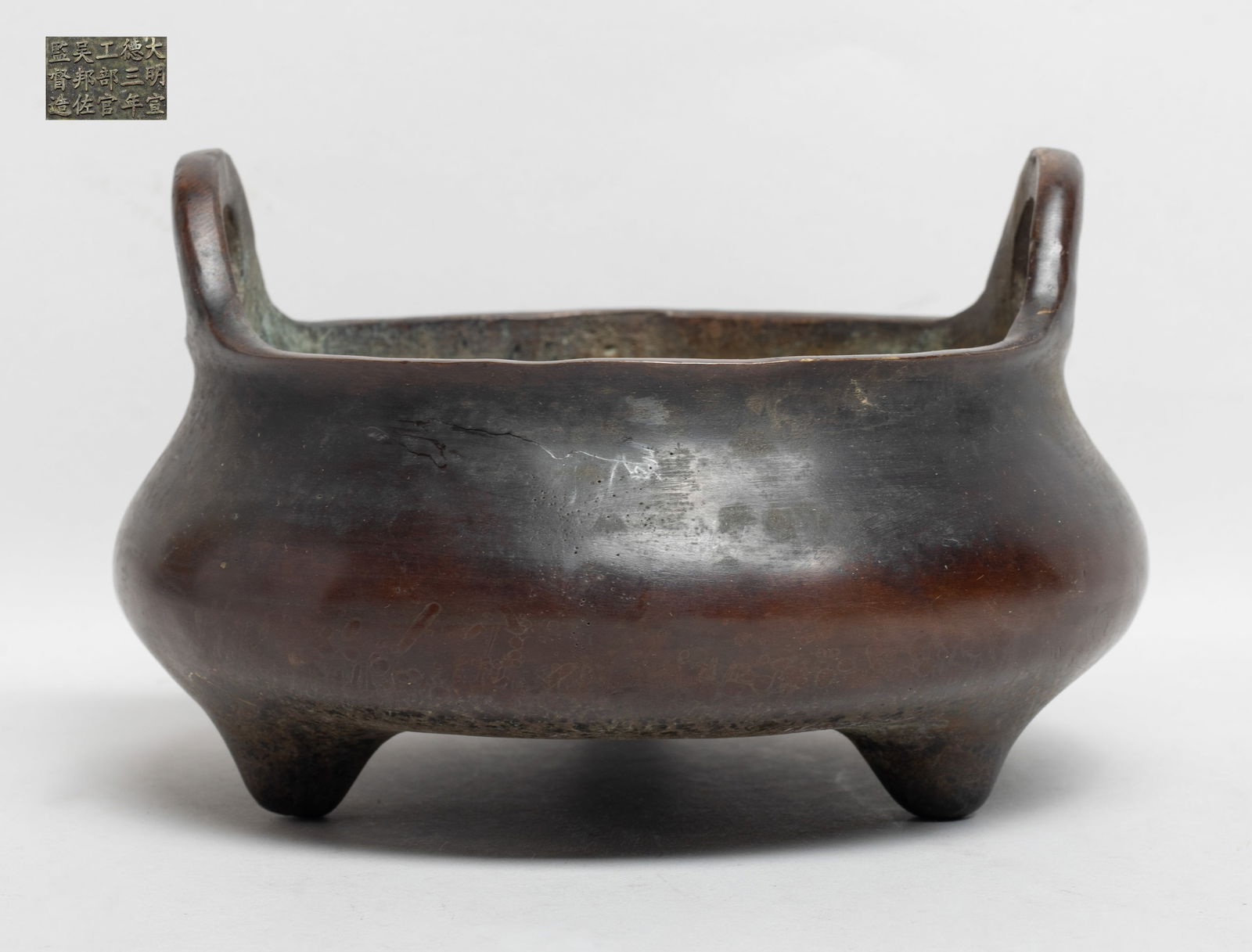 Estate Chinese Bronze Cabinet Censer: Of compressed form with three tapered feet and two upright handles, the bottom inscribed with mark of fifteen characters. Approx. 6.6*4.1 inch.