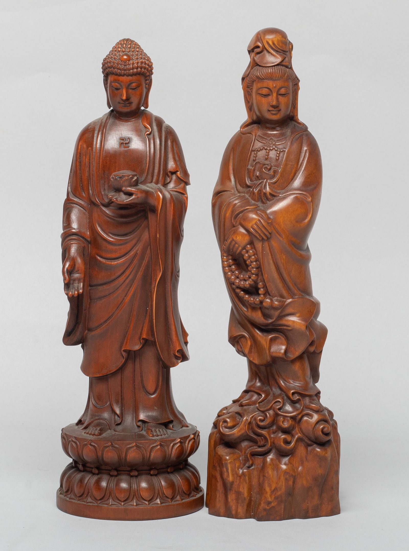 Two Chinese Export Wood Sculptures of Buddha: One Buddha carved standing on a waisted lotus base, the left hand holding a bowl, the other Buddha carved standing on clouds and rocks, the left hand holding prayer beads. Approx. 8.4*2.3*1.8 inch