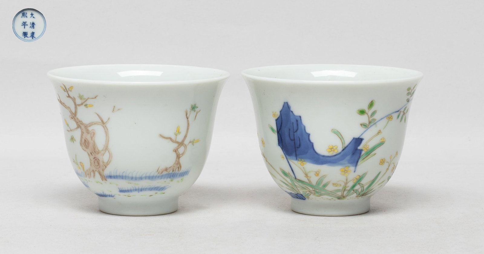 Two Chinese Export Porcelain Tea Cups: Each cup exterior painted flowers growing from rockery, inscribed with related poems, the bottom marked with six characters enclosed in double circles. Approx. 3.25*2.4 inch (each).