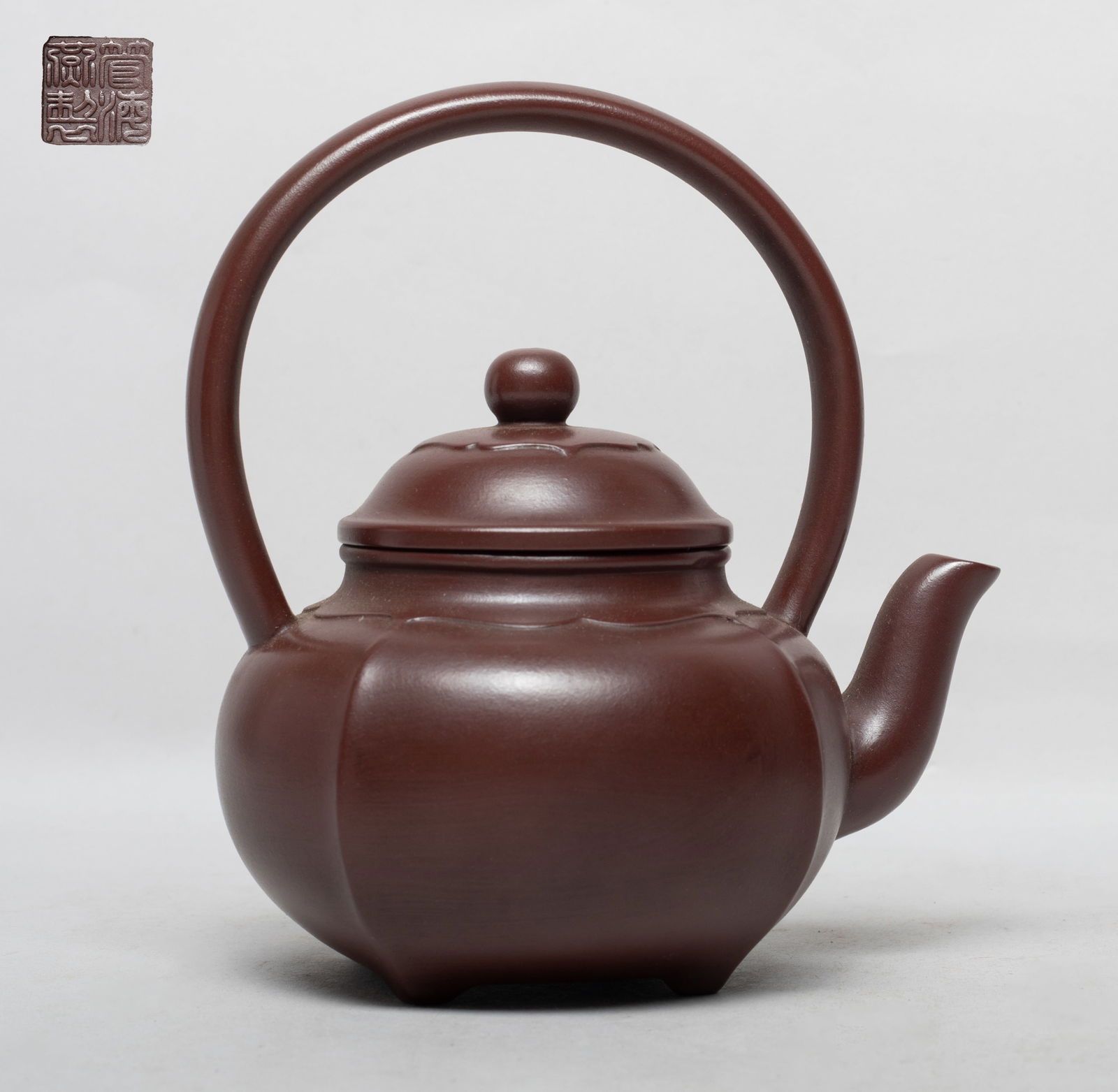 Chinese Export Yixing Zisha Tea Pot: The ovoid body of lobed form, the lid interior with two marks and the bottom with a seal mark. Approx. 6*5.9*4 inch.