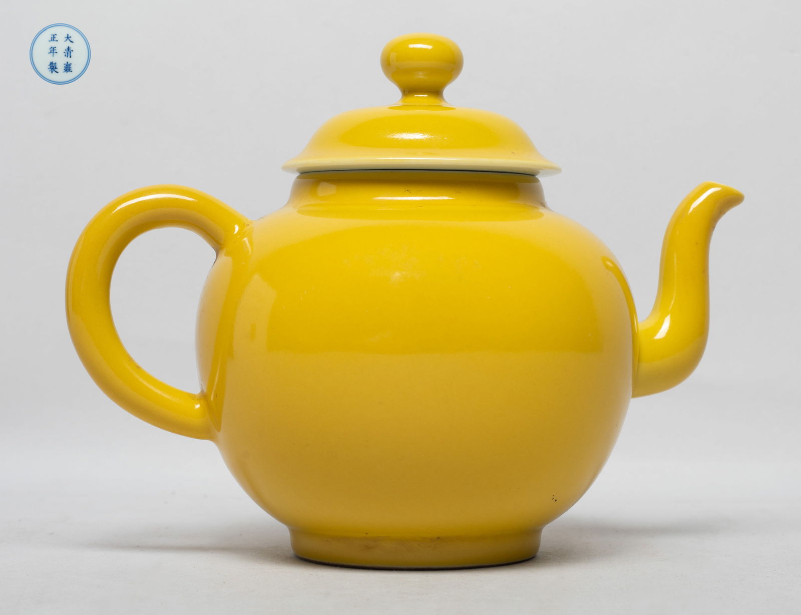 Chinese Rich Yellow Glazed Porcelain Tea Pot: The tea pot exterior covered with even yellow glaze, the bottom marked with six characters enclosed in double circles. Approx. 7.2*5.5*4.6 inch.