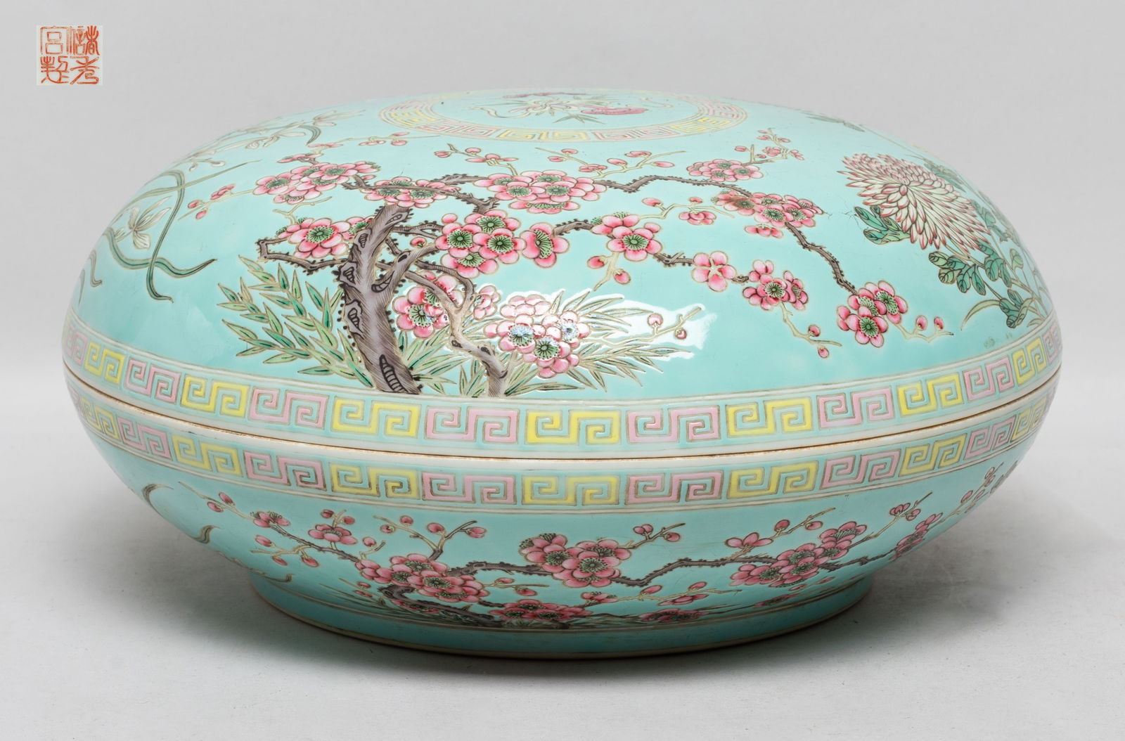 Rare Chinese Export Porcelain Covered Box: The box exterior enameled and painted with blossoming chrysanthemum, peony, orchid and plum blossom tree, a circular panel of lingzhi and bat at the centre, all against turquoise glazed body, the bott