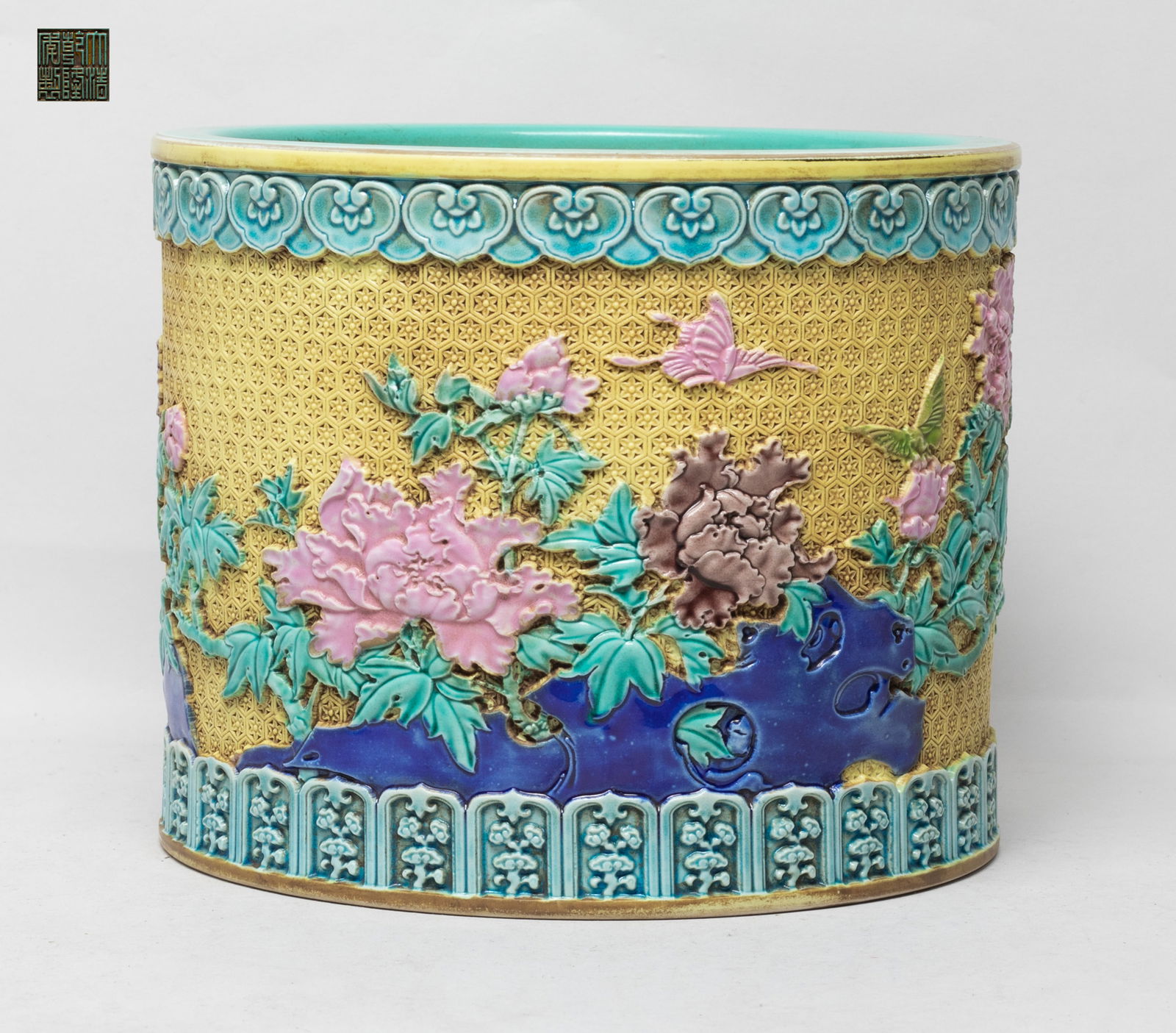 Large Chinese Export Porcelain Brush Pot: The exterior carved and glazed with flowers and butterflies between bands of ruyi heads and lappets of lingzhi, against reticulated yellow-glazed background, the interior turquoise glazed, the bottom
