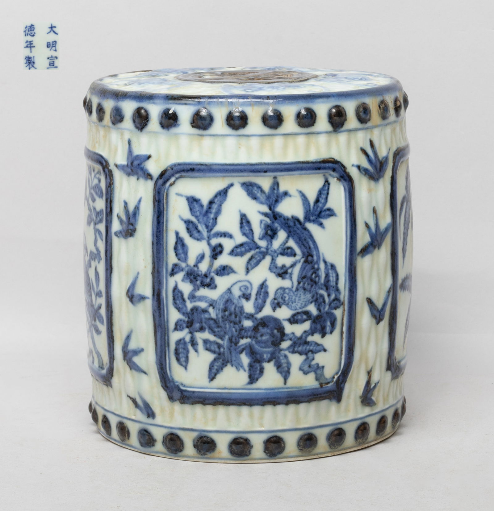 Chinese Blue & White Porcelain Sculpture: Of drum form, the sides painted with four panels enclosing bird and flowers, the top carved with five bats among clouds surrounding a central reticulated symbol, the bottom marked with six characters.