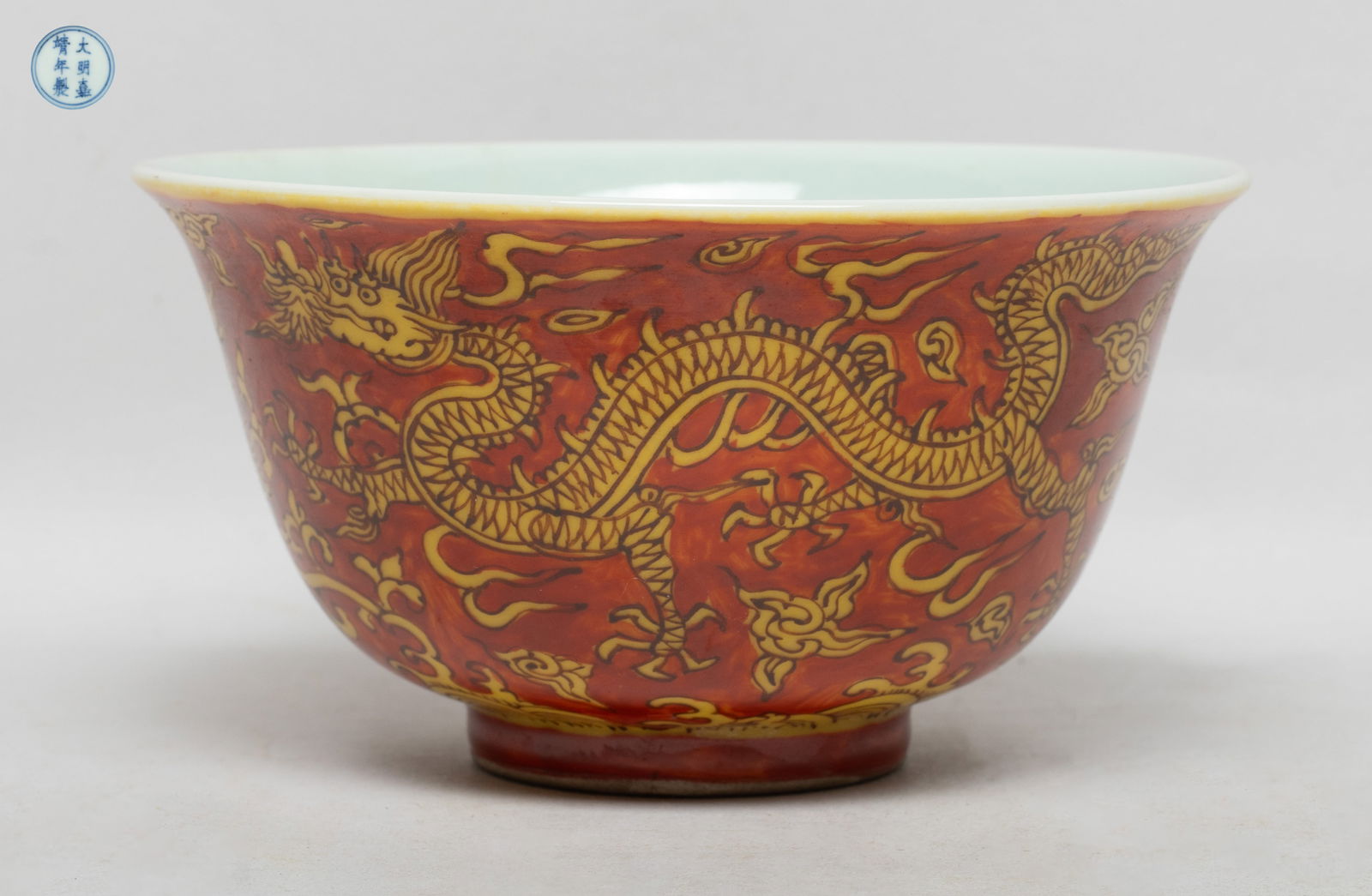 Estate Chinese Export Porcelain Bowl: The bowl exterior painted with a dragon and a phoenix amidst clouds and lingzhi above waves, glazed in yellow color on red glazed background, the bottom marked with six characters enclosed in double c