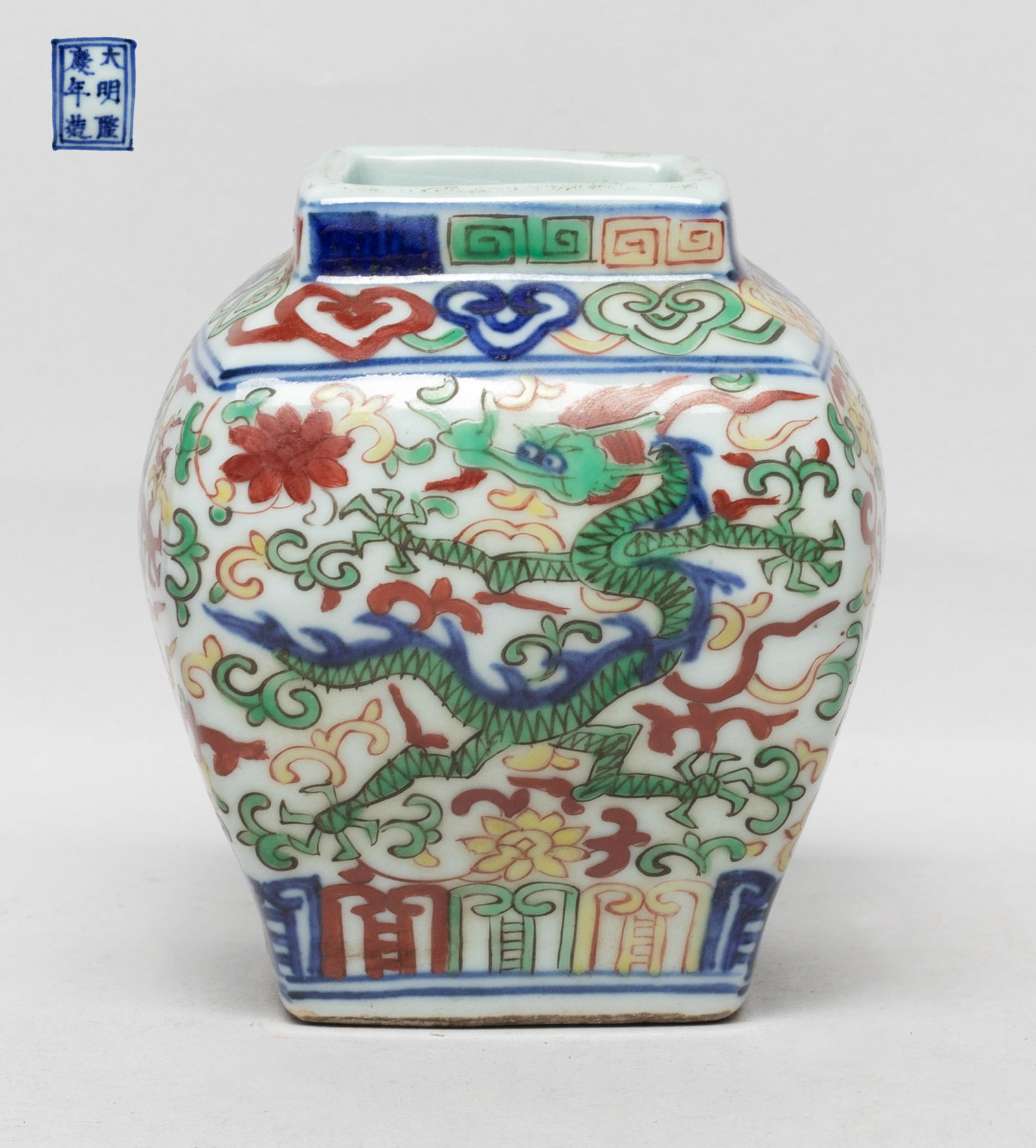 Chinese Wuchai Porcelain Dragon Jar: The ovoid body of square section, each side painted with a five-clawed dragon amongst lotus scrolls, between bands of ruyi heads and lappets, the bottom with a seal mark. Approx. 4.2*3.7*3.7 inch.