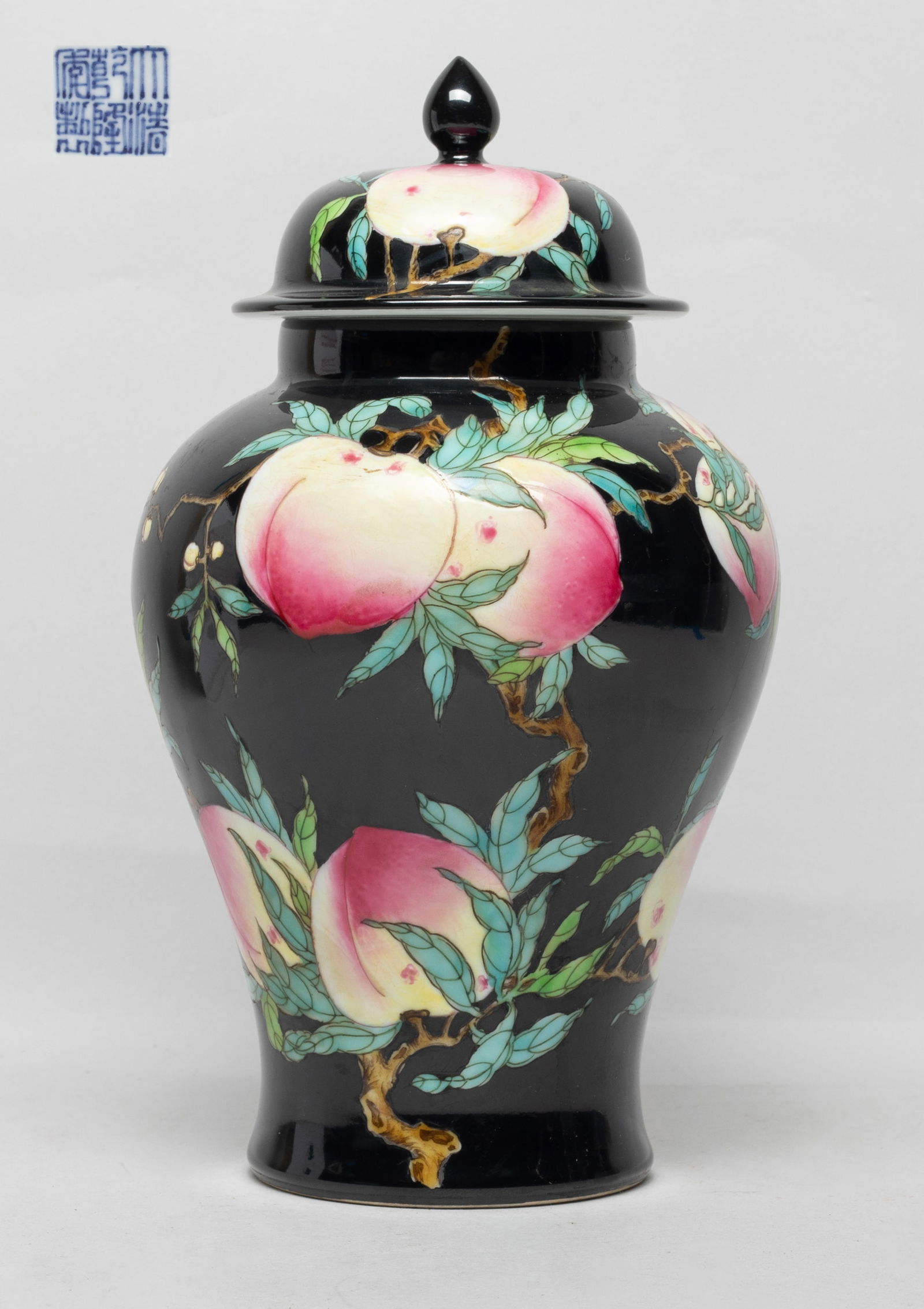 Collectible Chinese Porcelain Covered Vase: The vase body and lid exterior enameled and painted with a budding and fruiting peach tree and five copper-red bats on black glazed background, the bottom with a six-character mark. Approx. 9.2*5.3 in