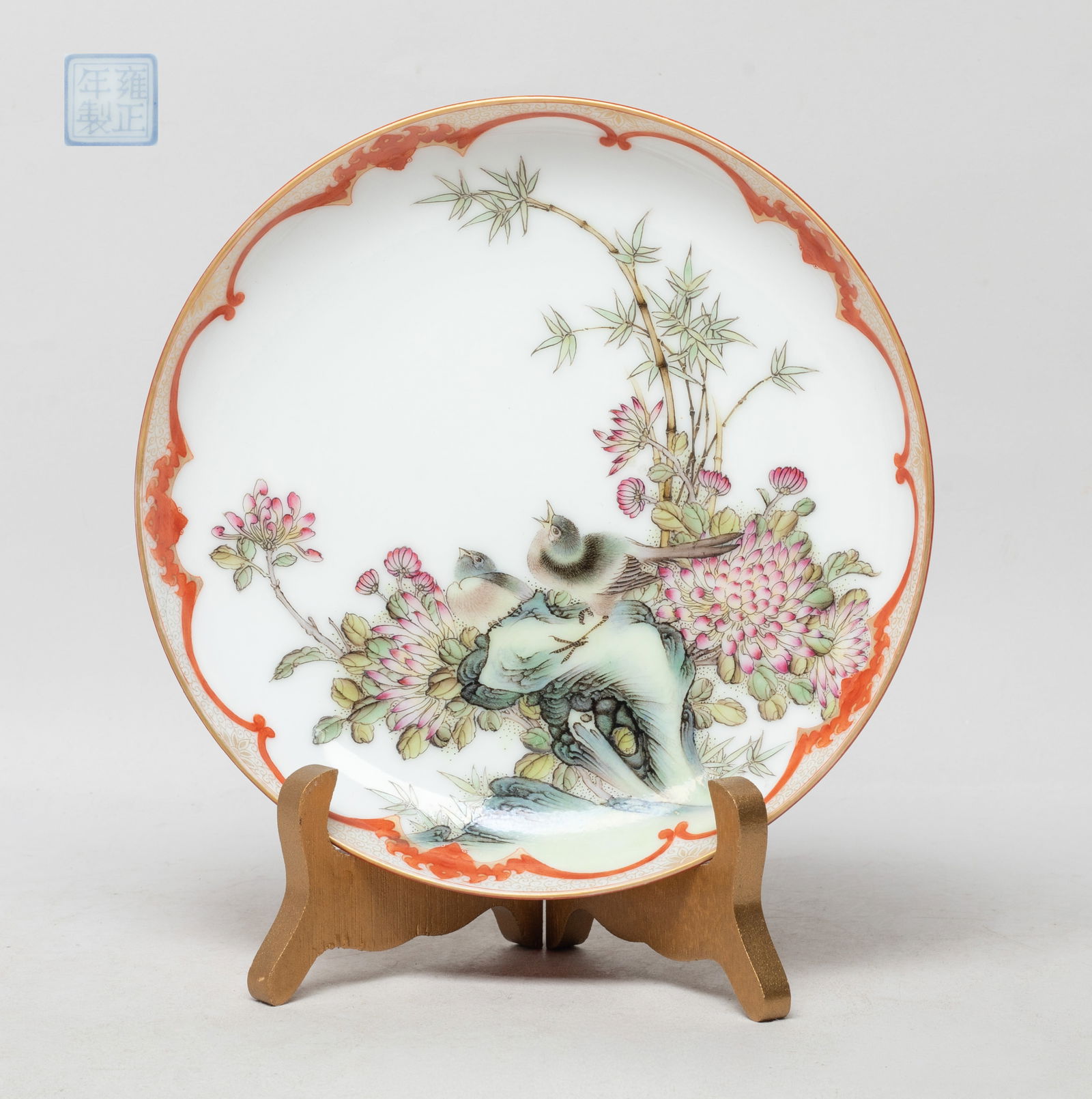 Chinese Enameled Porcelain Decor Plate: The plate interior decorated with two birds among bamboo, chrysanthemum and rockery, the exterior covered with copper red glaze, the bottom with a seal mark, with stand. Approx. 7.1 inch D (w/o stand)