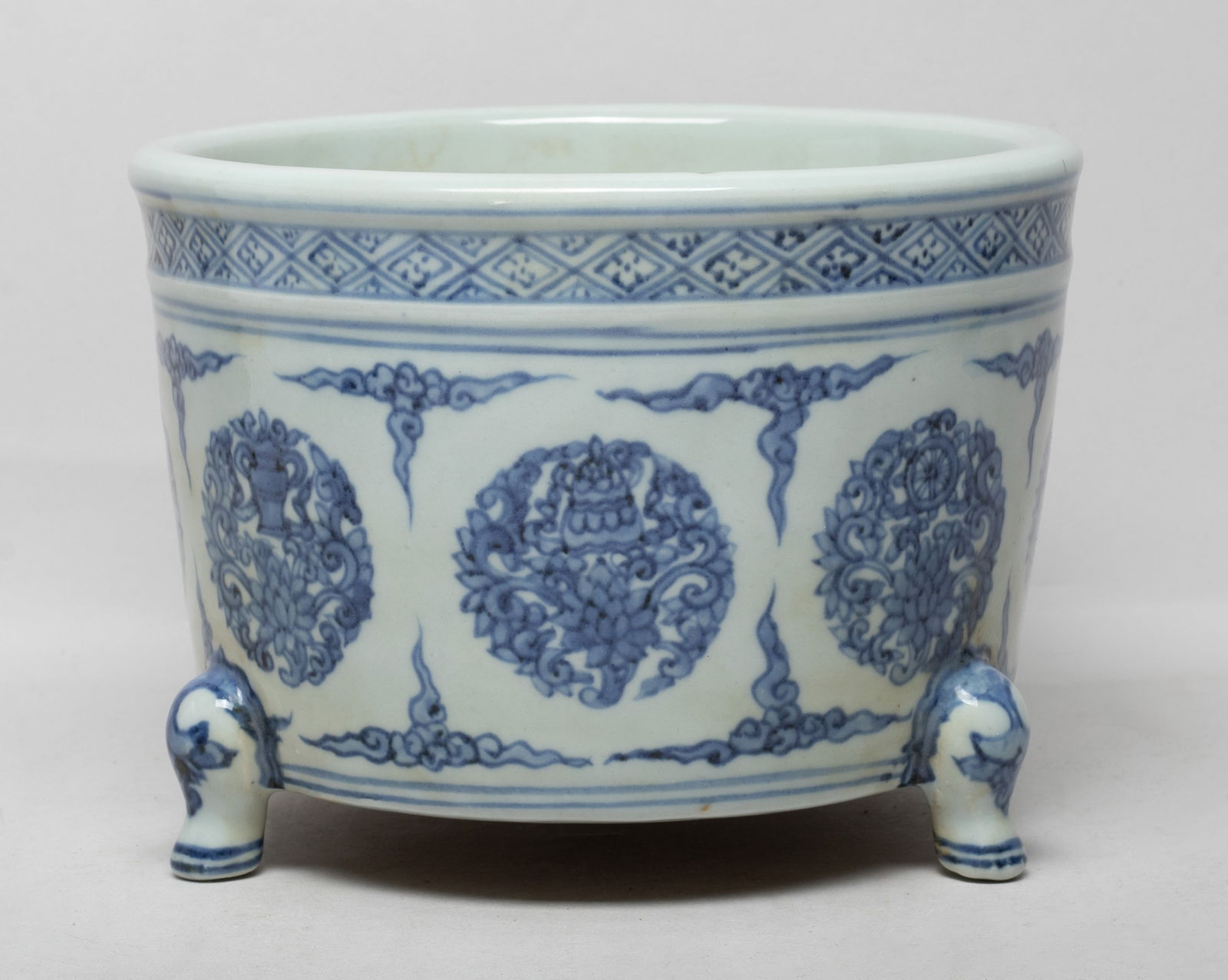 Large Chinese Blue & White Porcelain Censer: The censer exterior decorated with eight Buddhist treasures and lotus forming in circular shape, divided by scrolling clouds, under a fret band on the rim, all supported on three short legs. Approx. 7