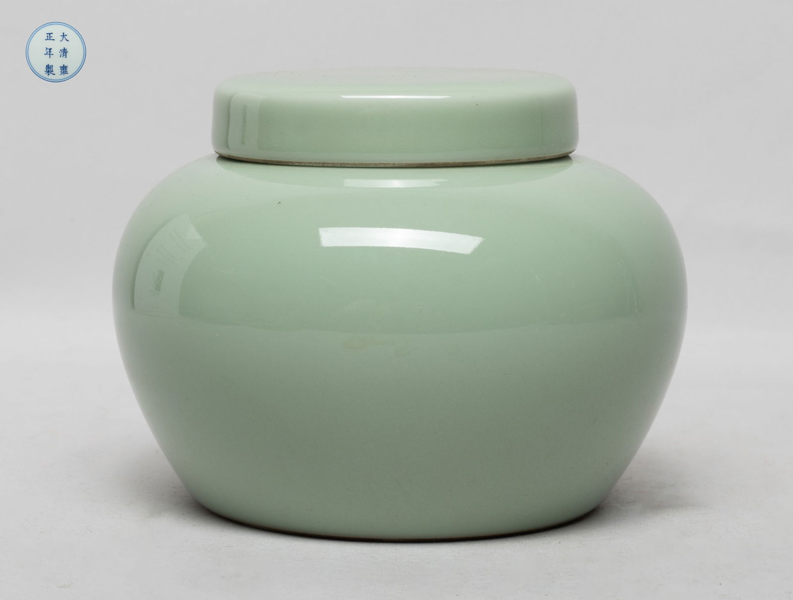 Chinese Bean Green Glazed Porcelain Jar: The jar body and lid exterior covered with even celadon glaze, the bottom marked with six characters enclosed in double circles. Approx. 5.1*3.9 inch.