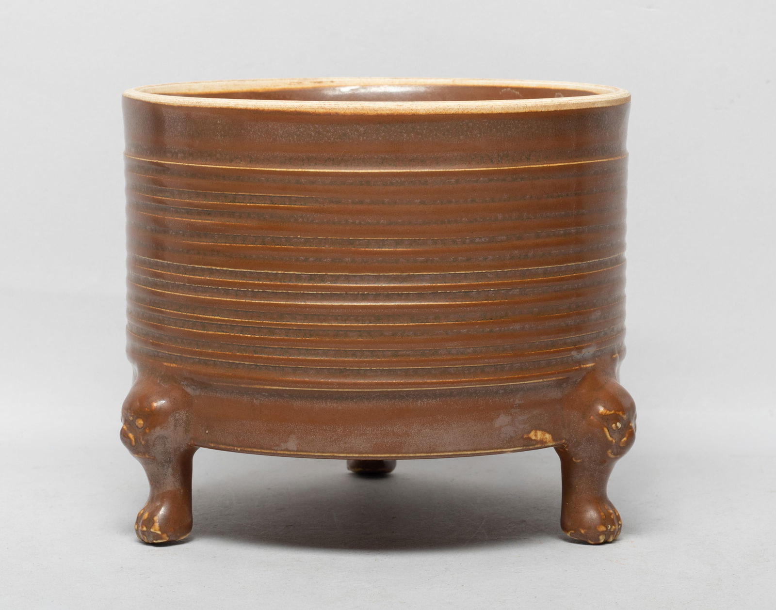 Collectible Chinese Ding Type Porcelain Censer: Of cylindrical form supported on three cabriole legs, the exterior carved with raised borders and applied with brown glaze. Approx. 6.1*5.1 inch.