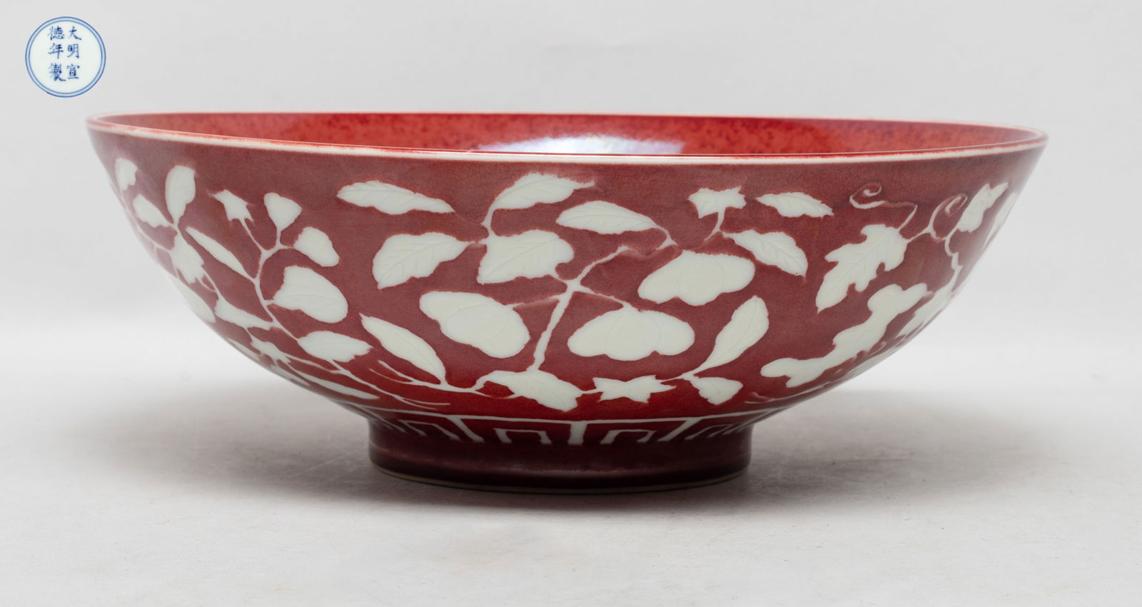 Chinese Export Large Porcelain Bowl: The bowl exterior incised with flowers and various fruits, glazed in white color against red glazed background, the bottom marked with six characters enclosed in double circles. Approx. 10*3.5 inch.