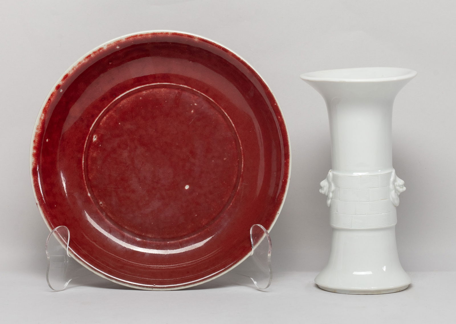 Chinese Export Porcelain Plate & Vase: The plate inside and out applied with rich red glaze, the vase of archaic gu form, the central section carved in raised relief with two raised masks on a band of leiwen motif, applied with even white