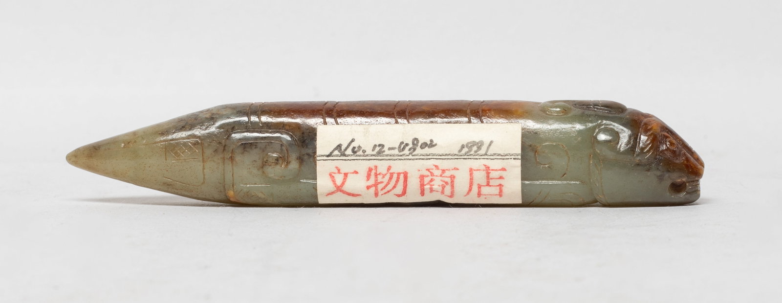 Rare Chinese Russet Jade Long Pendant: Chinese russet jade pendant of stylized beast form, with a single horn and an elongated body. Approx. 4.17*0.68*0.57 inch. The Estate of the Consignment Store Closed Sale, Palm Springs. CA. 2022.