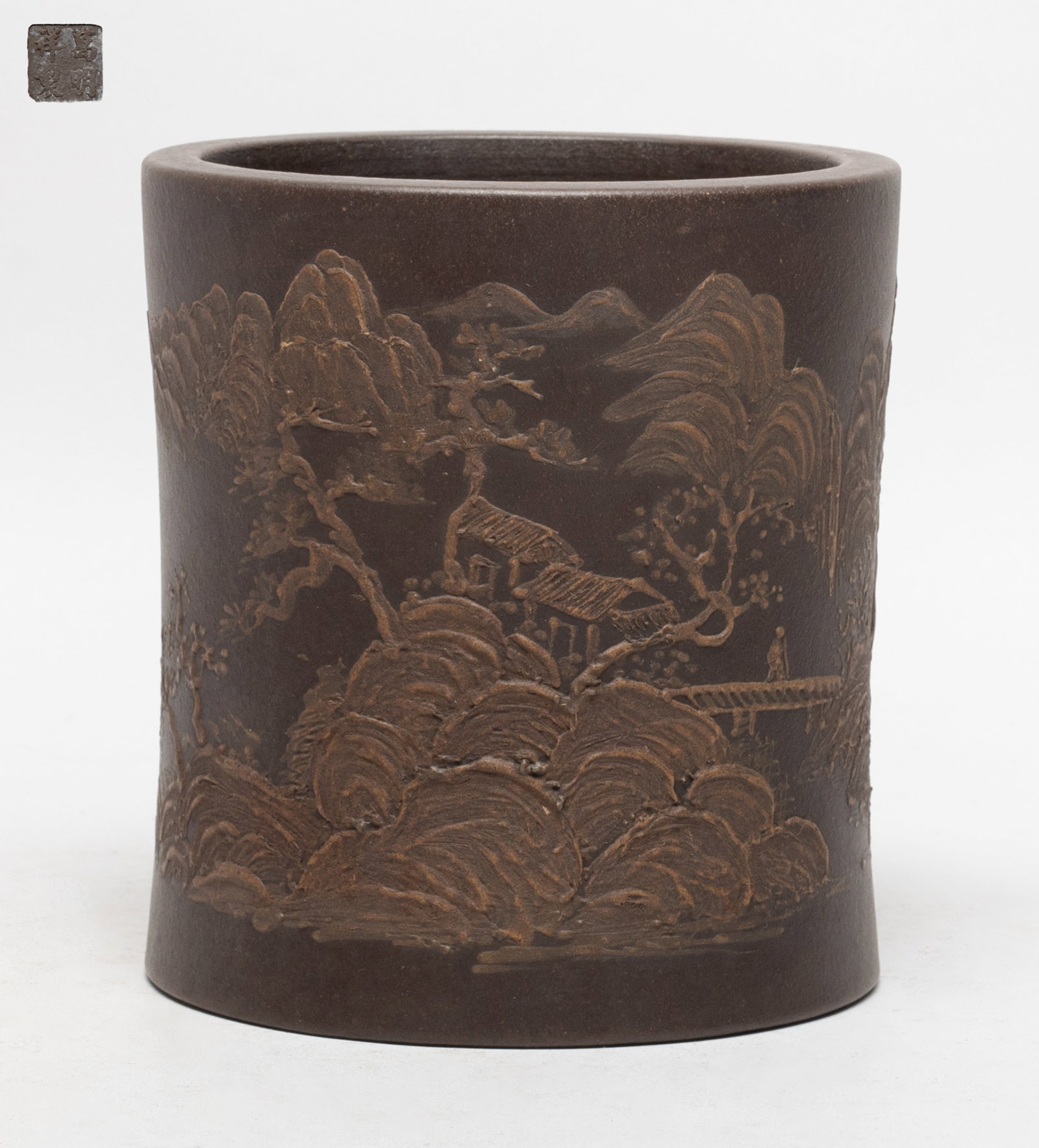 Chinese Yixing Zisha Brush Pot: Of cylindrical form, the exterior decorated with continuous mountain landscape scene, the bottom with a four-character mark. Approx. 4.5*4.8 inch.