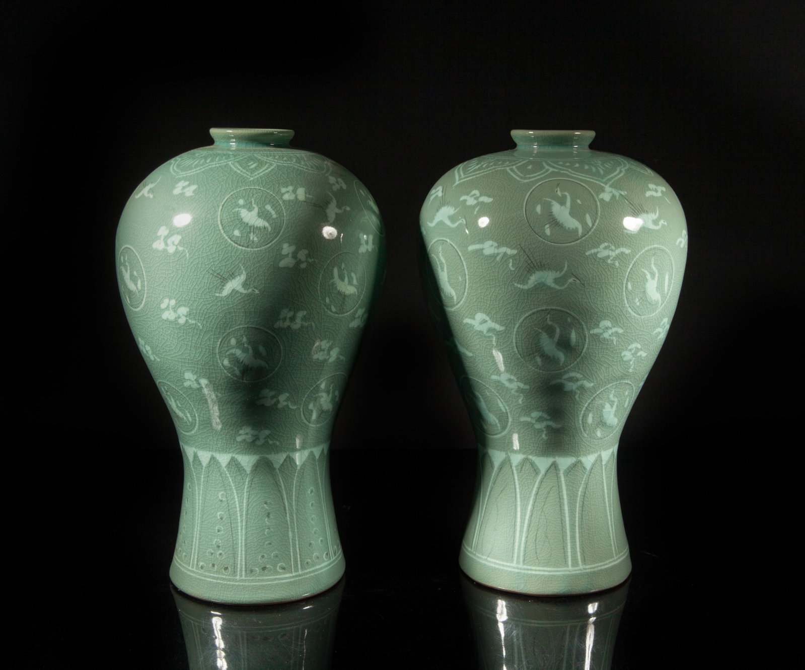 Vintage Signed Korean Tall Porcelain Vases: Each of ovoid form rising from a spreading foot, the exterior painted with cranes flaying amidst clouds between bands of petals, all against crackled celadon glazed ground, the bottom marked with two