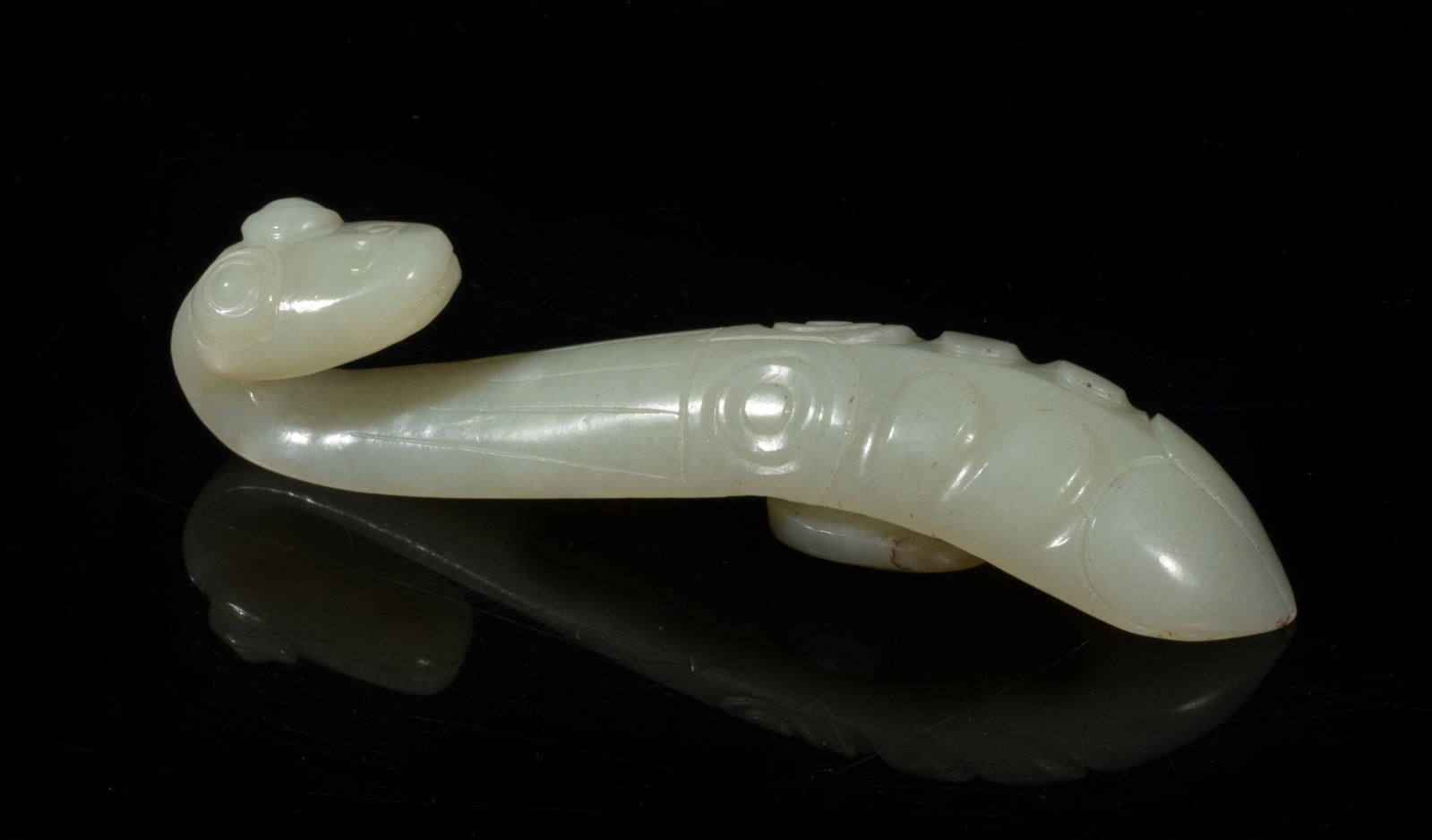 Estate Chinese Jade Carved Belt Buckle: The terminal deftly carved as the head of a praying mantis depicted with bulging eyes, the lower section of the arched shaft naturalistically modeled in the form of a cicada, the underside with a