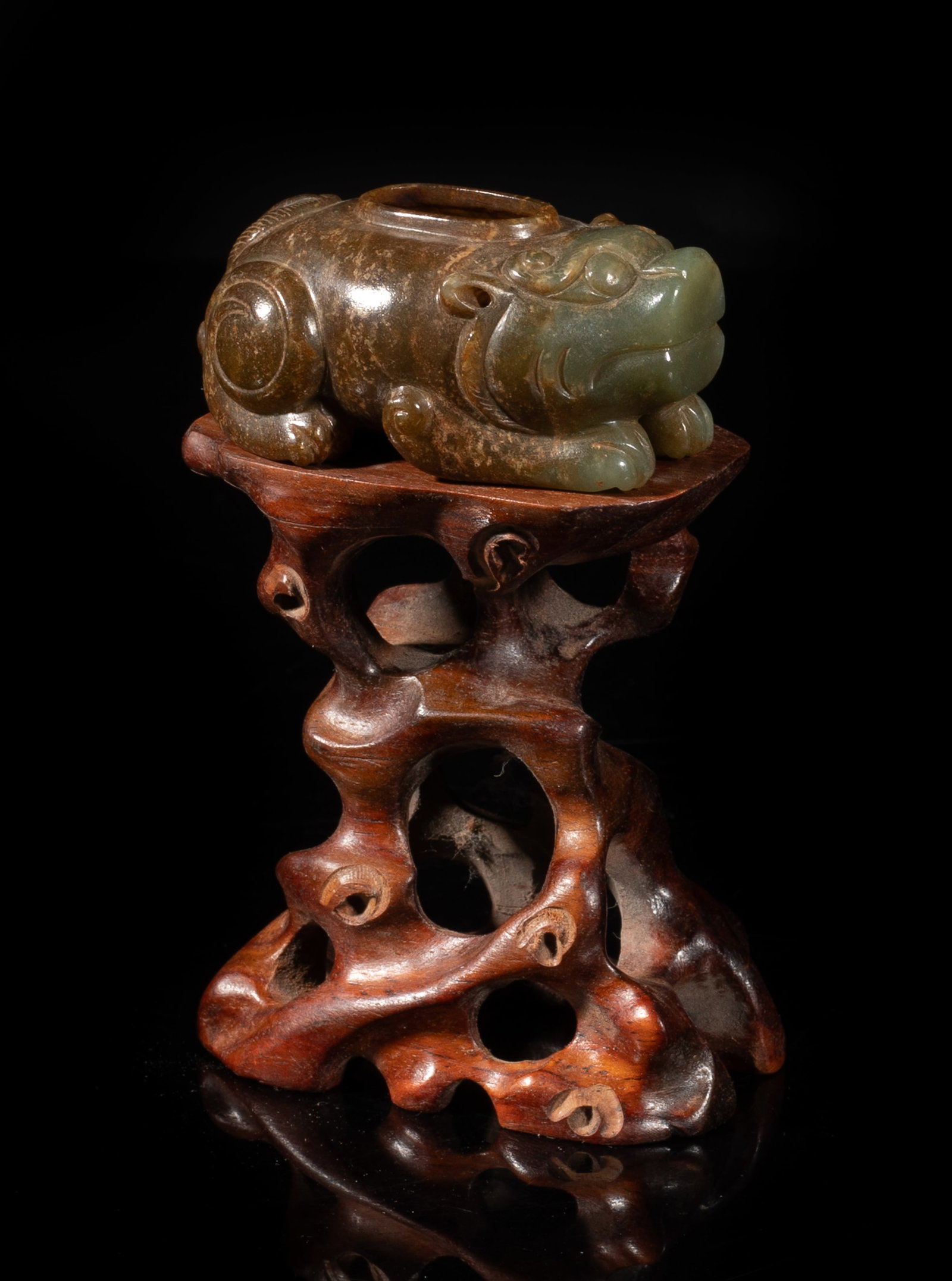 Chinese Russet Jade Water Pot on Stand: Carved of recumbent beast form, its four legs tucked under the body, with bulging eyes and wide nose, with a tall wood stand. Approx. 2.53*1.72*1.13 inch (jade size). The Estate of the Downtown Los