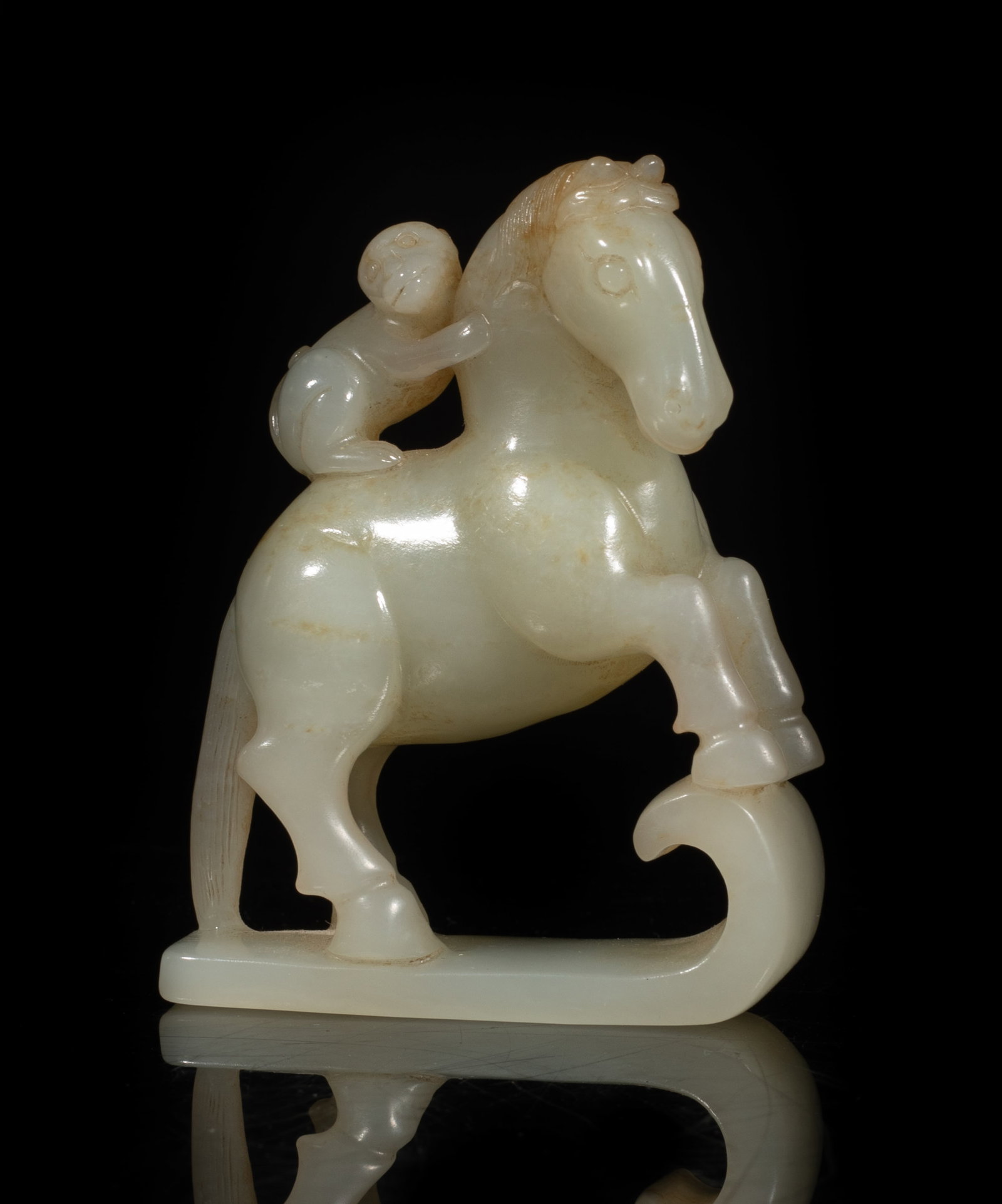 Chinese Jade Carved Sculpture of Horse: Crisply carved as a standing horse with front legs lifting upward and head turned slightly to right, a monkey perched precariously on its back and clasping on the horse neck, the stone with some