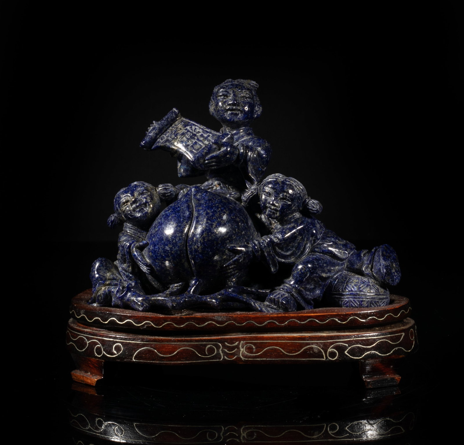 1950-70s Chinese Lapis Table Sculpture: Carved with two children holding a big peach, and another child sitting above and holding a banner in his hand, with a wood stand. Approx. 5.4*6.4*3.3 inch (w/ stand). The Estate of the Los Angeles.