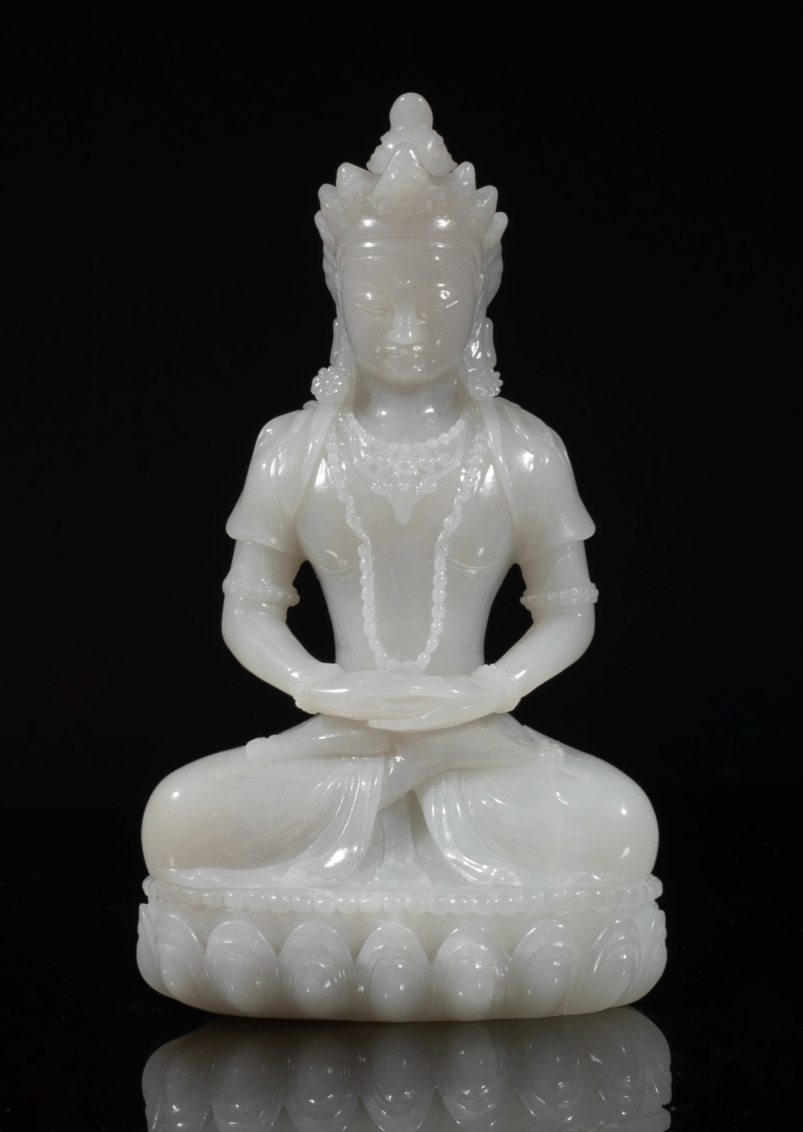 Chinese Jade Carved Sculpture of Buddha: The Buddha carved seated in dhyanasana on a lotus base, the hands in dhyana mudra, wearing a delicate diadema and beaded necklaces. Approx. 5.5*3.15*1.78 inch. The Estate of the Lee & Family, Los