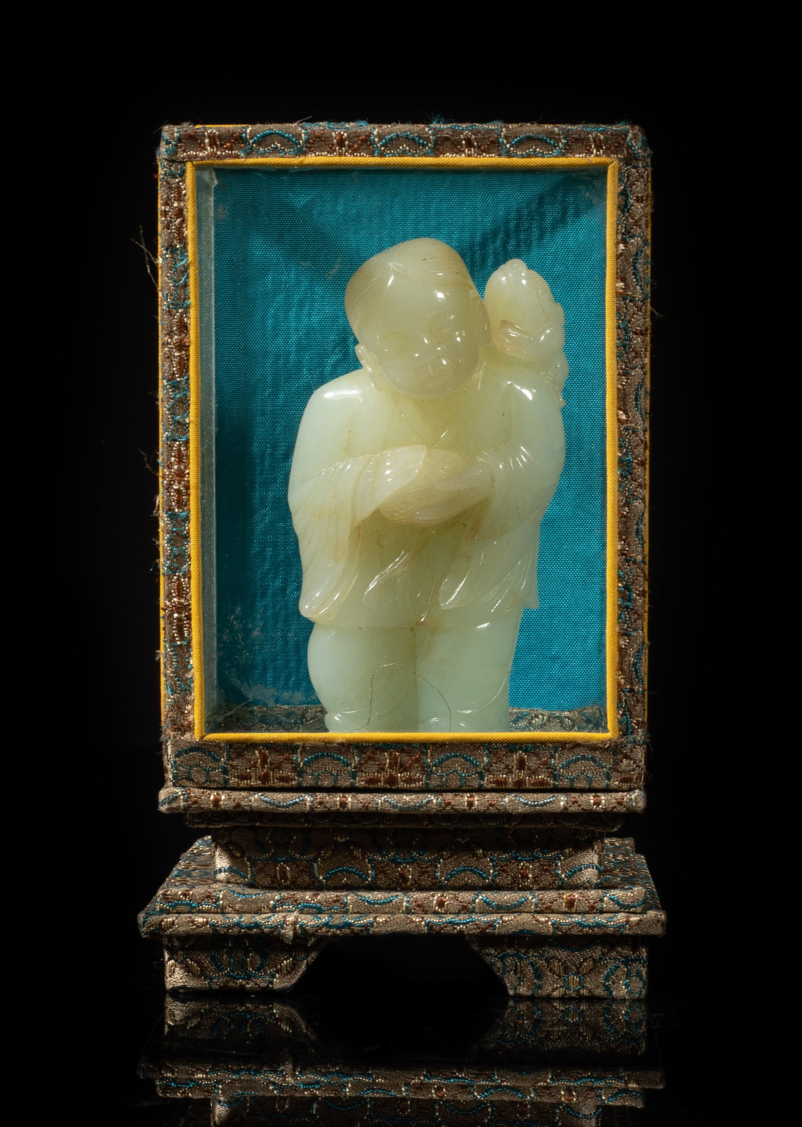 Chinese Jade Carved Figure w/ Glass Case: Chinese russet jade carved figure, the head slightly tilted to the right, the hands holding a covered box, a toad clambering on the shoulder, with a glass case. Approx. 3.25*1.7*0.95 inch (jade size).