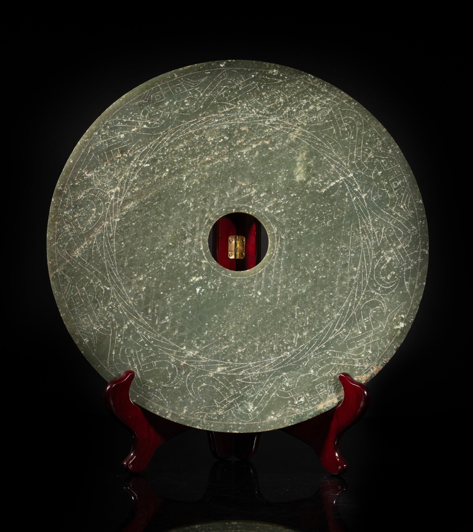 Large Chinese Early Type Jade Carved Bi: Large circular shape mottled moss-green jade bi, either side incised with a band of archaistic beasts framing geometrical motif, with a stand. Approx. 12 inch D (w/o stand).