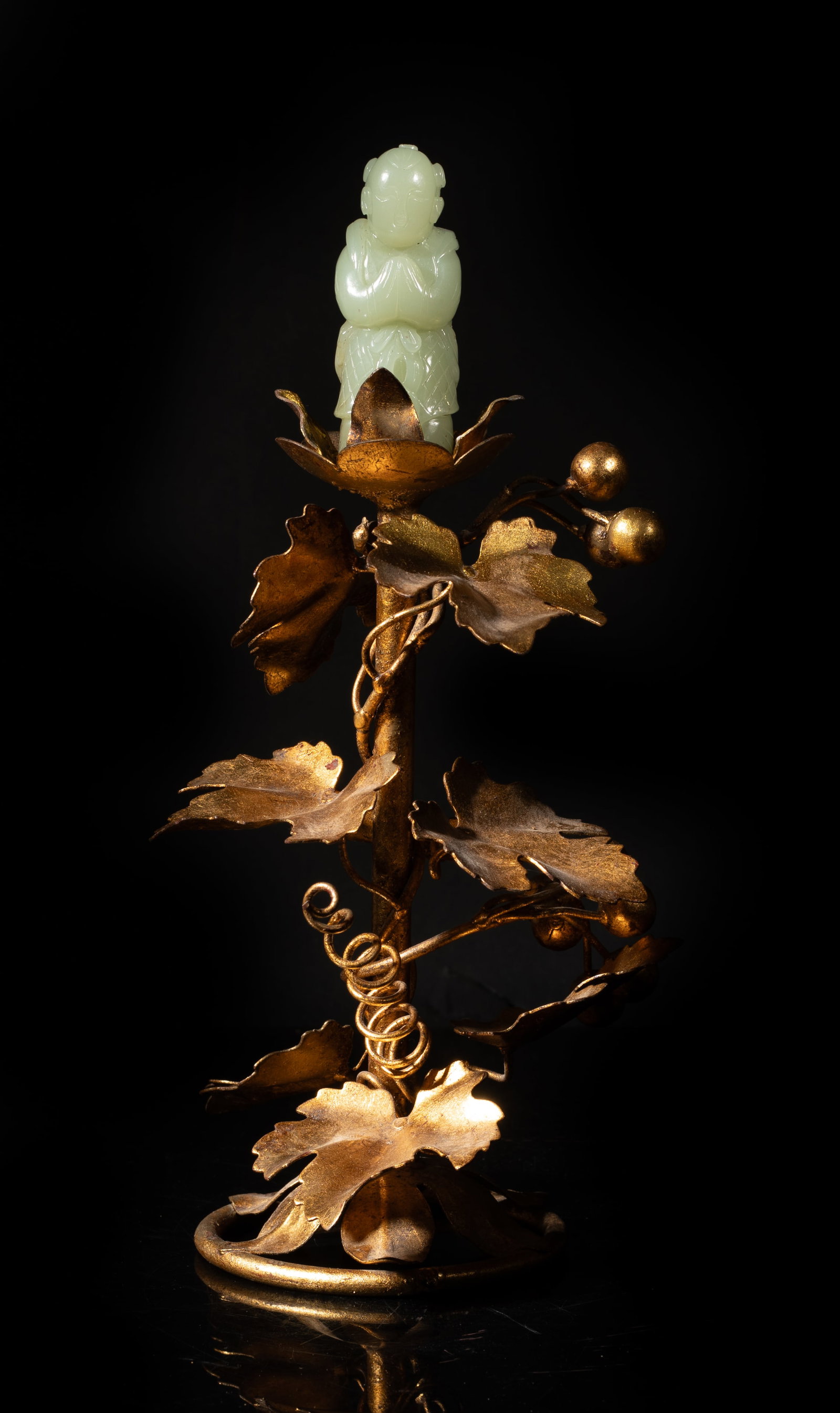 Early 20th Chinese Export Jade, Brass Sculpture: The vintage brass sculpture moulded as a leafy fruit tree, supporting a pale celadon jade sculpture carved as a standing boy with his palms together. Approx. 10.8*5.5*4.5 inch.