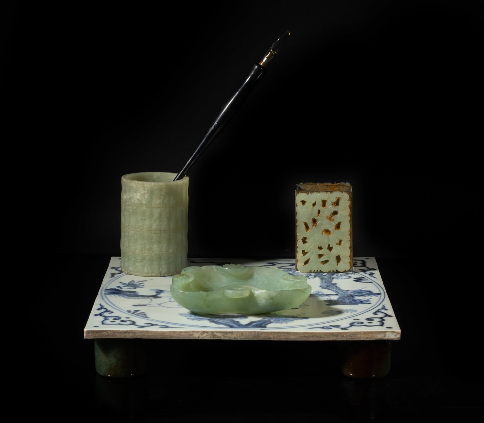 Early 20th Chinese Export Jade Writing Sets: The blue and white porcelain tile base decorated with a scholar and a boy beneath a gnarled pine tree, with a jade washer, a brush pot, and case and a pen. Approx. 7.8*7.8*4 inch (w/o pen).