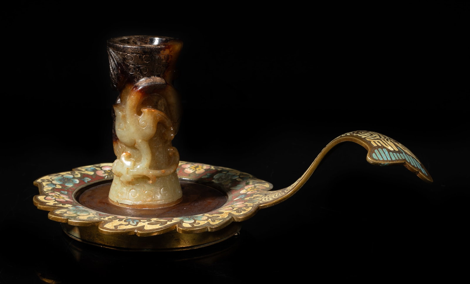 Early 1900s Chinese Jade, Enameled Candle Holder: Chinese floral form enameled piece with a curled handle, with a russet jade candle holder of waisted shape, carved in high relief with a chi dragon. Approx.
