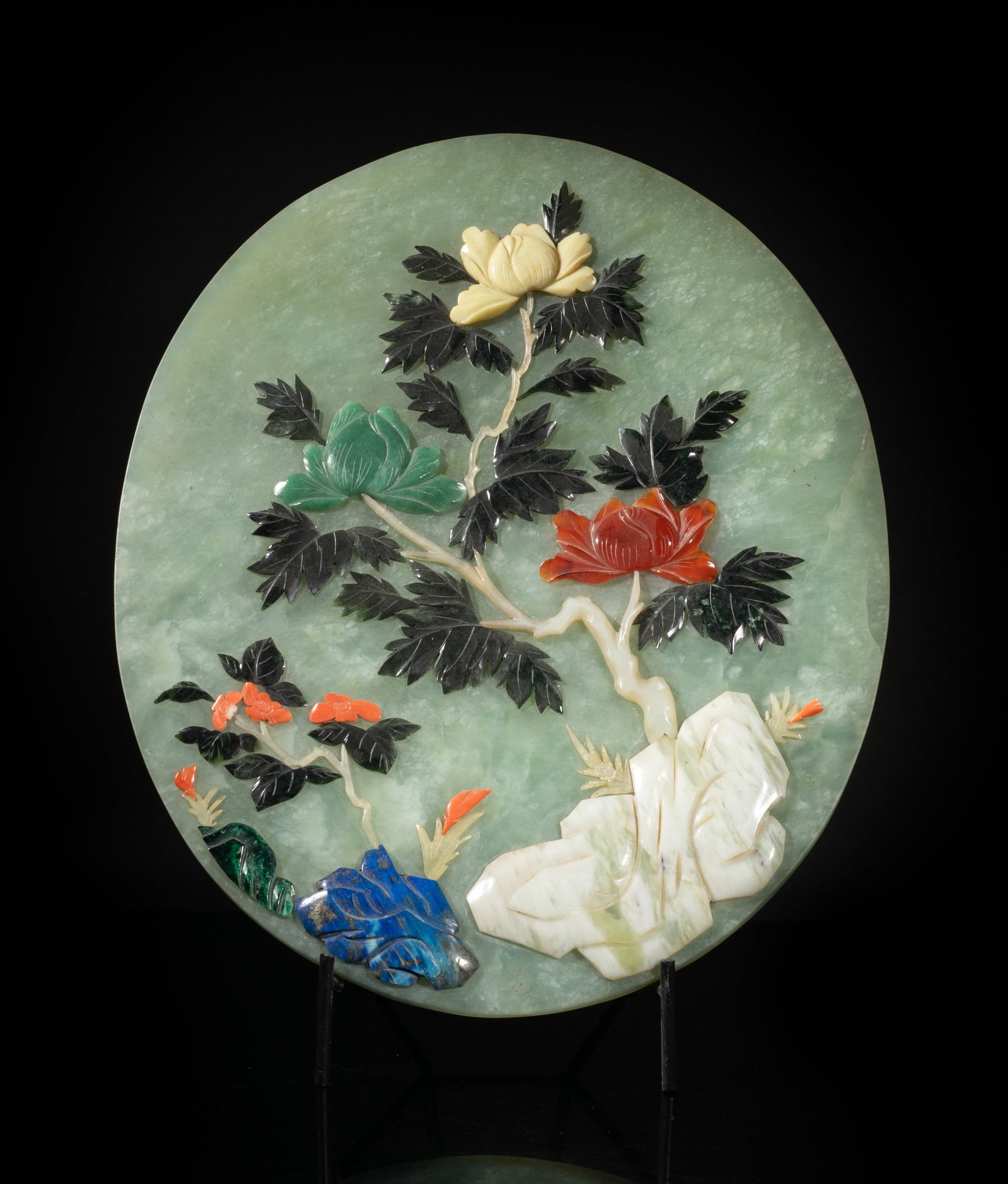 Large Chinese Jade Carved Table Screen: Of oval shape, inset with multi gemstone and carved as blossoming flowers issuing from rock, with stand. Approx. 13*10.7 inch (w/o stand).