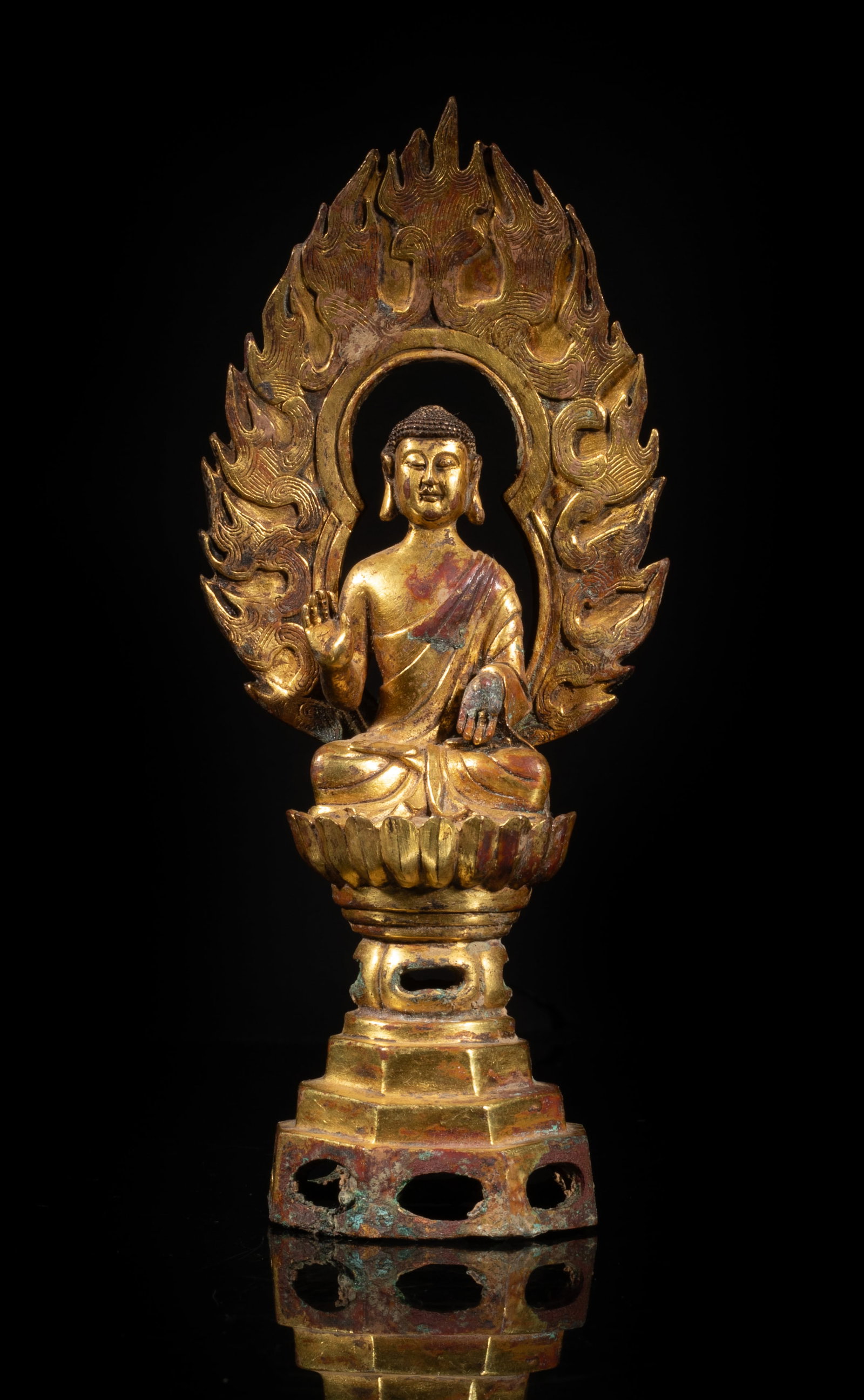 Chinese Gold on Bronze Sculpture of Buddha: The Buddha cast seated on a lotus throne with a tall pedestal, the hands in abhaya mudra pointing to opposite directions, flame shaped mandorla on his back. Approx. 6.8*2.9*1.7 inch.