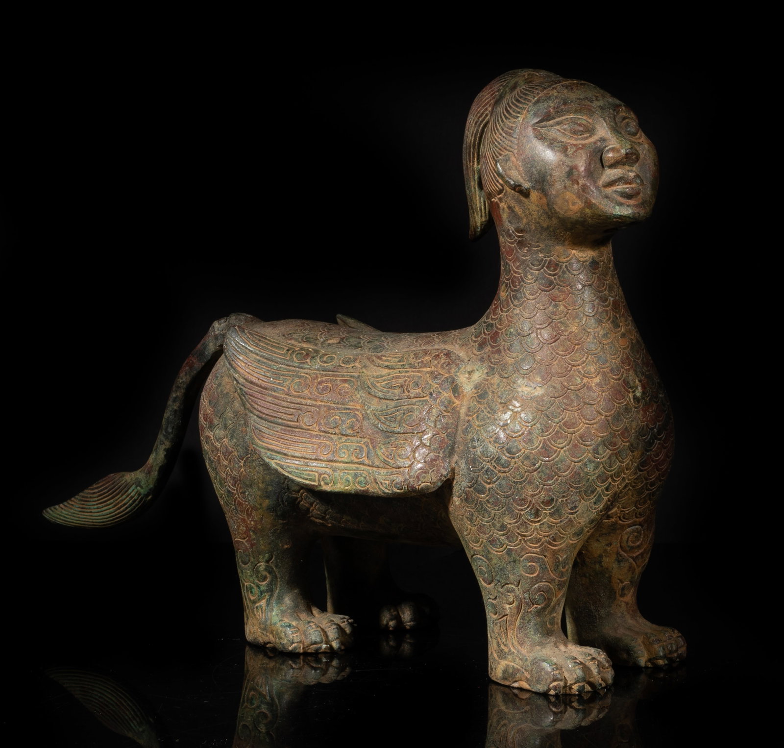 Estate Special Chinese Bronze Sculpture: Cast as a mythical creature with a human head, a scaly beast body, a pair of wings and a long tail, the face with almond-shaped eyes, a protruding nose, and full lips. Approx. 10.5*8*7.8 inch. The
