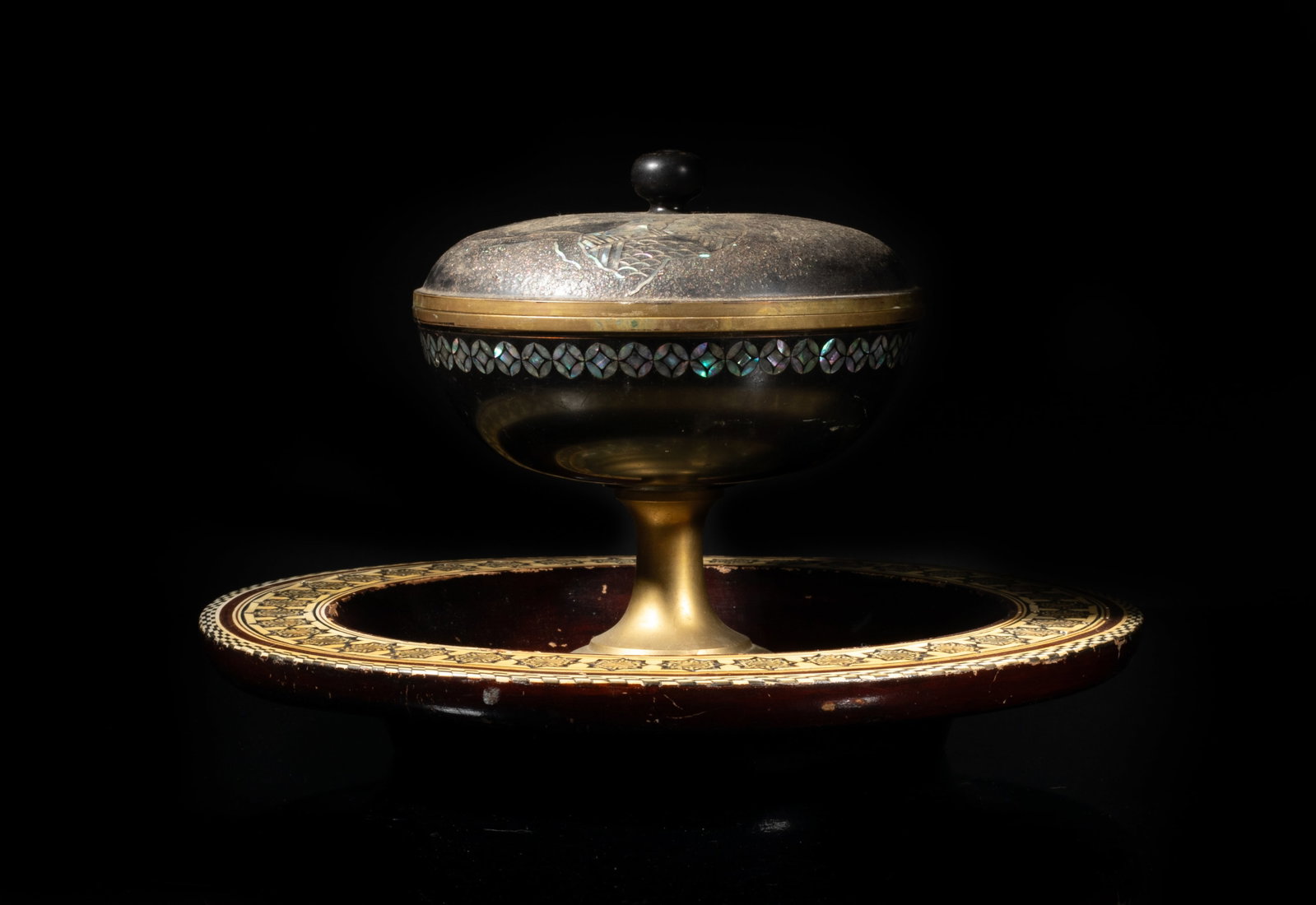 Two Chinese Lacquer Inlaid MOP Center Pieces: The lacquer centerpiece bowl inlaid with mother-of-pearl and carved with delicate patterns, the tall covered bowl inlaid with mother-of-pearl on the cover and carved as two scholars in landscape.