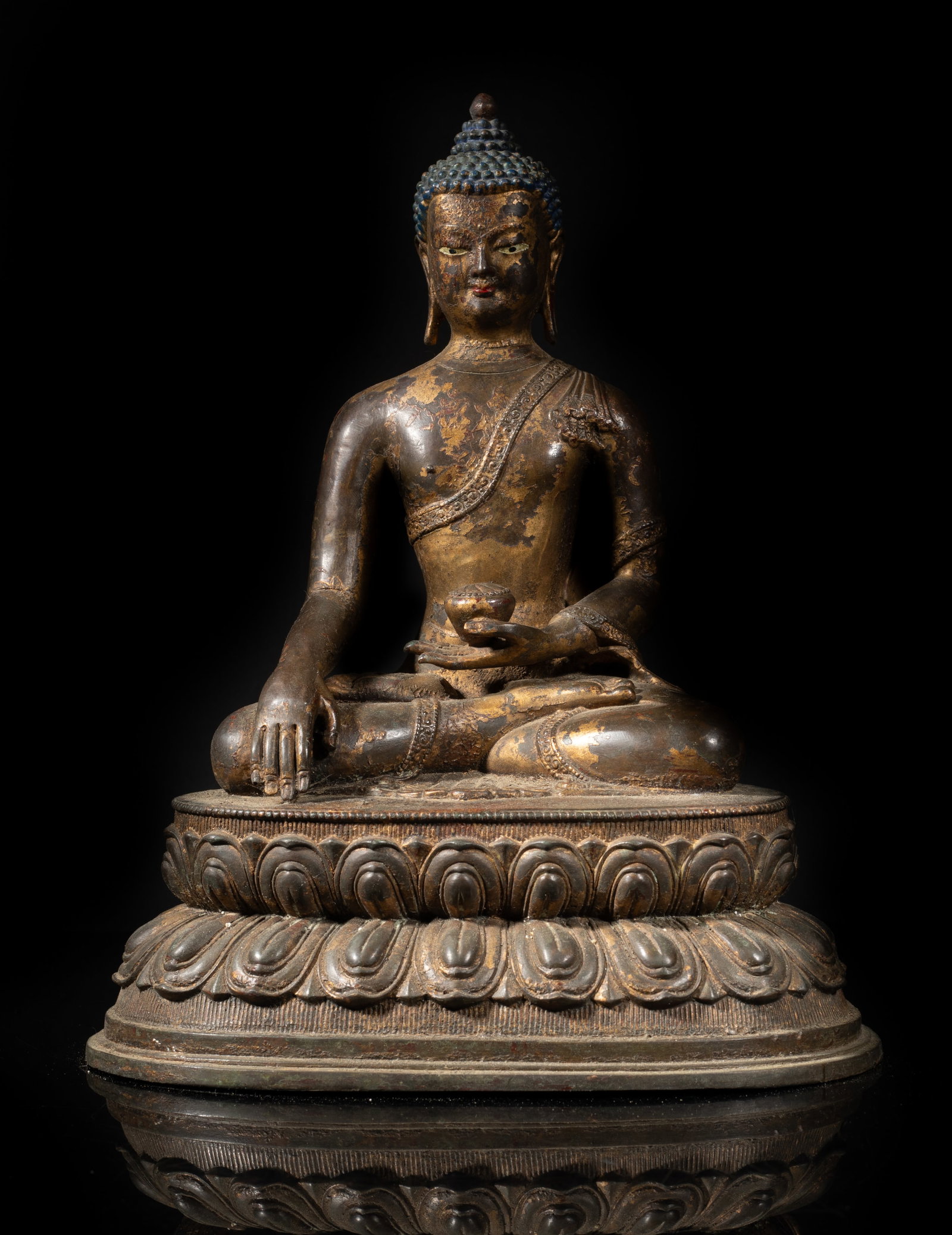 Estate Chinese Gilt Bronze Sculpture of Buddha: The Buddha cast seated in seated in dhyanasana on a double-layered lotus base, his left hand holding a bowl and right hand resting on knee, the meditative face with serene expression. Approx. 9.8*4.9*