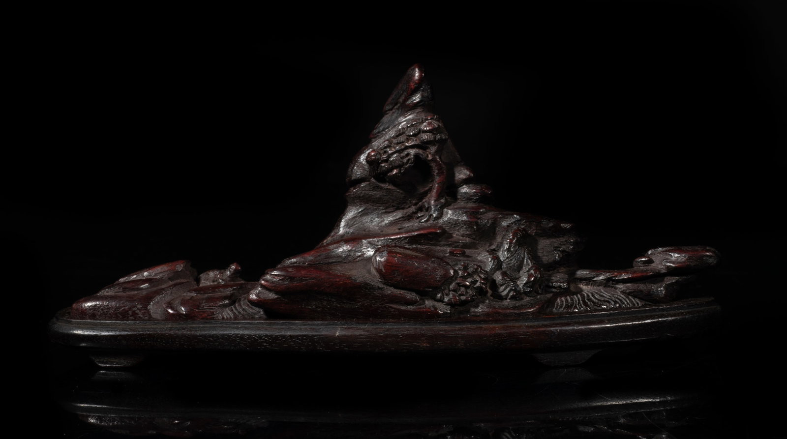 Chinese Bark of Agarwood Table Sculpture: Chinese bark of agarwood carved in the shape of mountain range, with a seated scholar, a tree and a beast, matched wood base. Approx. 6*2.4*1.8 inch (w/ base).