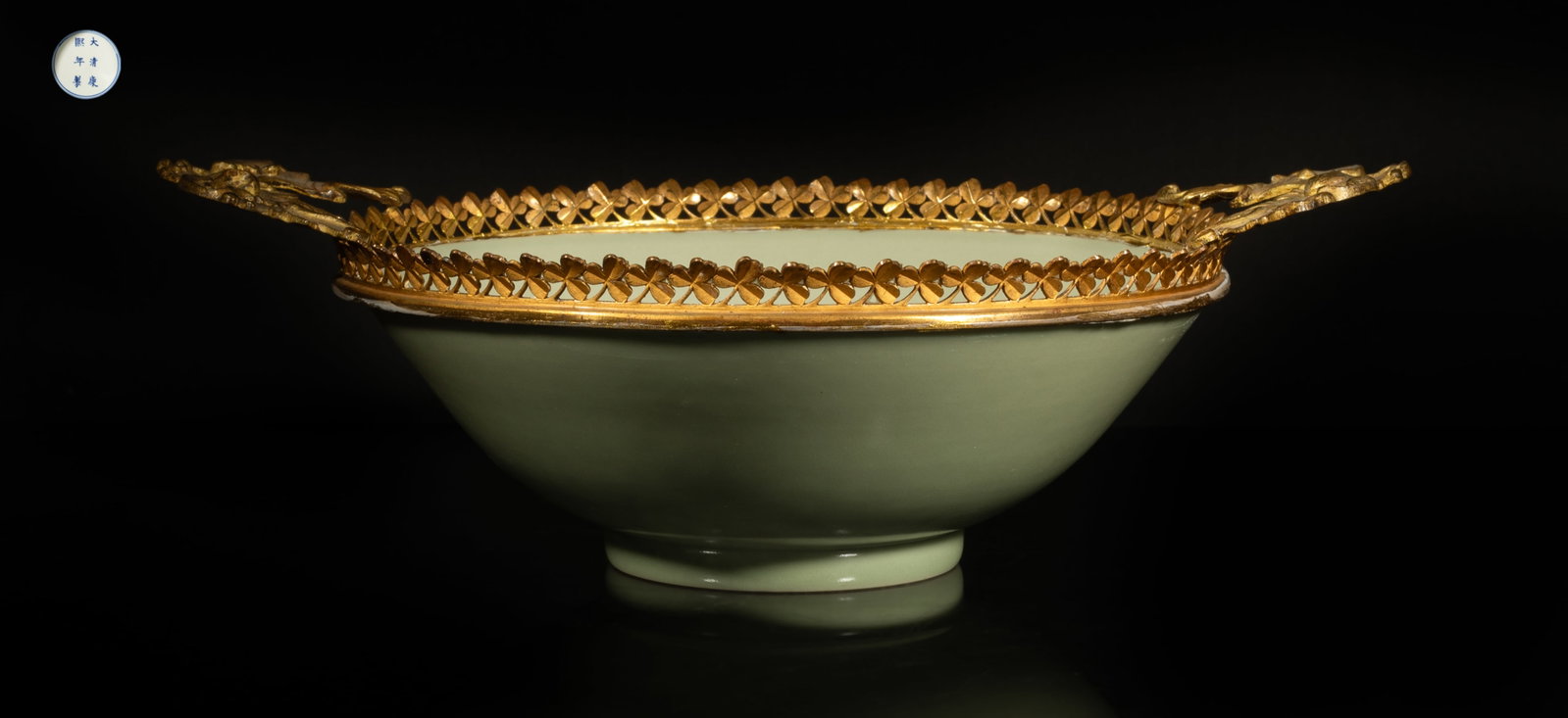 Large Chinese Bean Green Glazed Porcelain Bowl: The bowl inside and out applied with even bean green glaze, the bottom marked with six characters enclosed in double circles, with metal cast rim. Approx. 12*8.6*3.8 inch. The Estate of the Mary & Mar