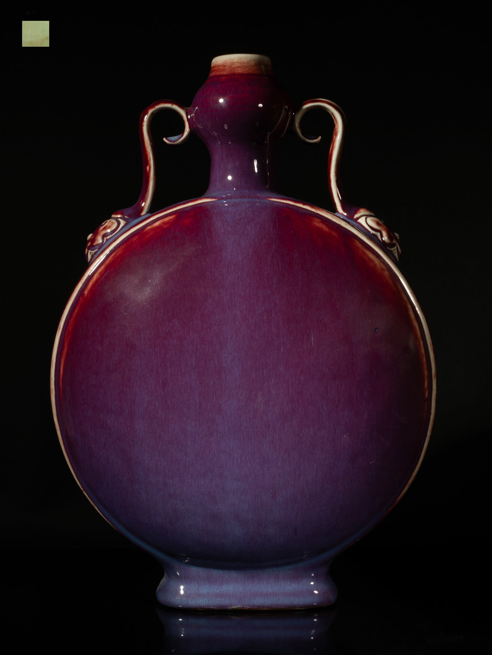 Tall Chinese Flambe Glazed Porcelain Vase: Of flattened rounded form rising to a short neck and a garlic mouth flanked by two ruyi handles, the exterior applied with red glaze thinning to white color at the rims, suffused with lavender blue st