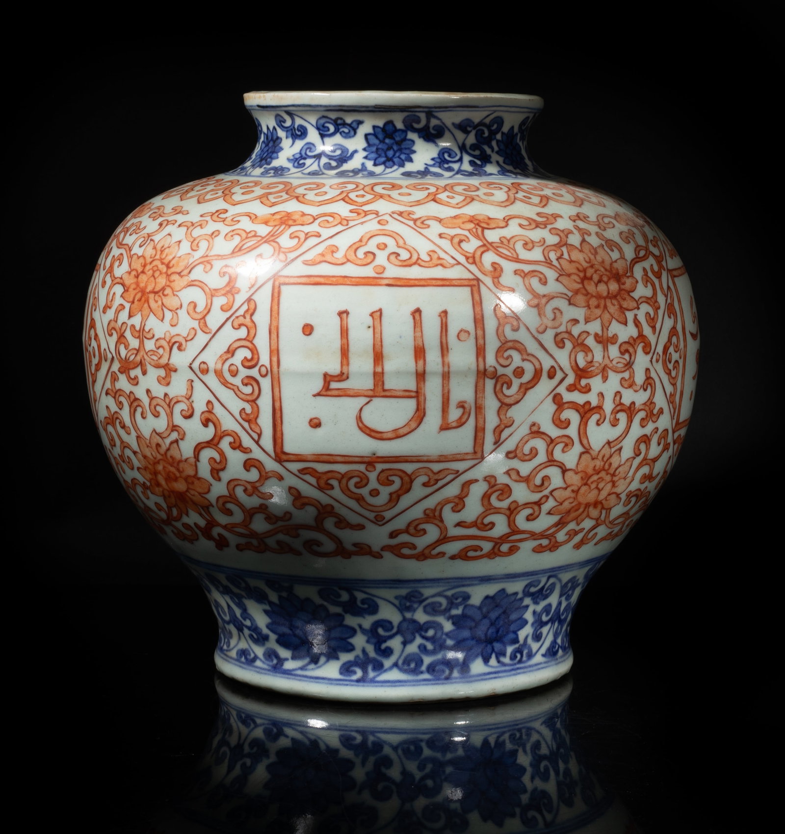 Large Chinese Export Porcelain Jar: The ovoid body exterior painted in copper red with dense lotus scrolls encircling four rectangular frames enclosing stylized characters, under a band of ruyi heads, all between bands of lotus sprays i