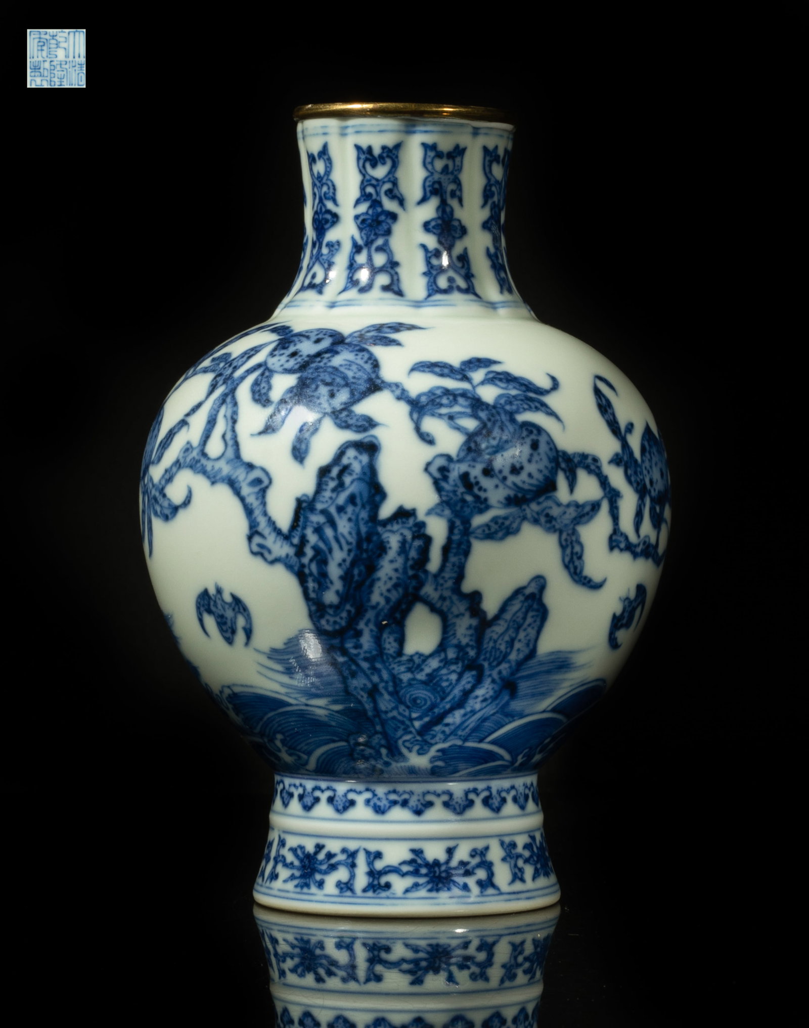 Chinese Blue & White Porcelain Vase: The ovoid body rising from a splayed foot to a lobed neck, painted with a peach tree growing from rock over waves, five bats flying around the tree, the foot and neck with foliage motif, the bottom