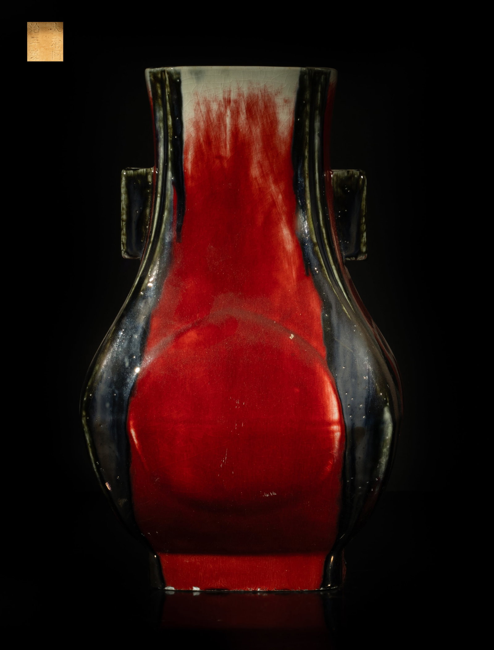 Chinese Flambe Glazed Porcelain Vase: Of archaic bronze shape, covered to the exterior with a streaked glaze of red, black and black tones, the interior similarly decorated with a mottled black glaze, the unglazed bottom incised with six 