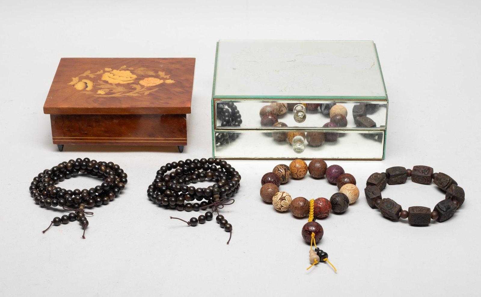 Two Boxes Chinese/ South Asian Wood Beads: Including two long strings of wood beads, one string of beads carved with Buddha and one string of beads carved beasts, coins and flowers, with two jewelry boxes. Approx. 140 gram (total bead weight).