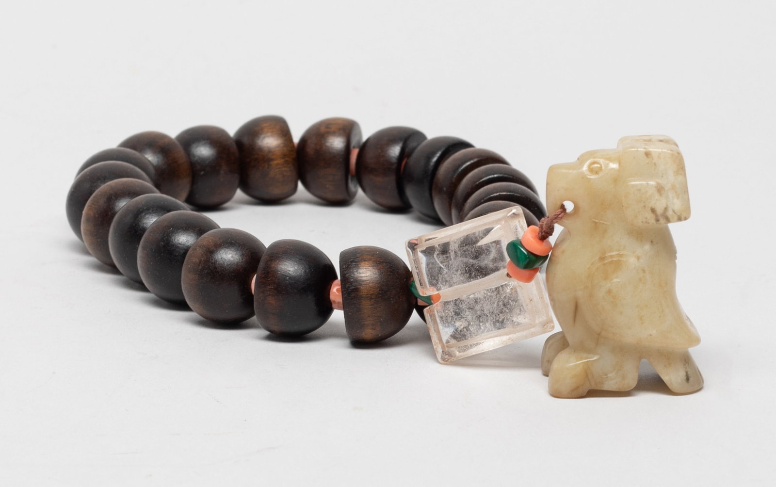 Unusual Chinese agarwood, Jade Prayer Beads: A string of Chinese agarwood prayer beads, suspended with a crystal pendant, and a jade pendant carved of stylized bird form. Approx. 1.8*1.1*0.8 inch (jade size). The Estate of the Judy & Mark. Los