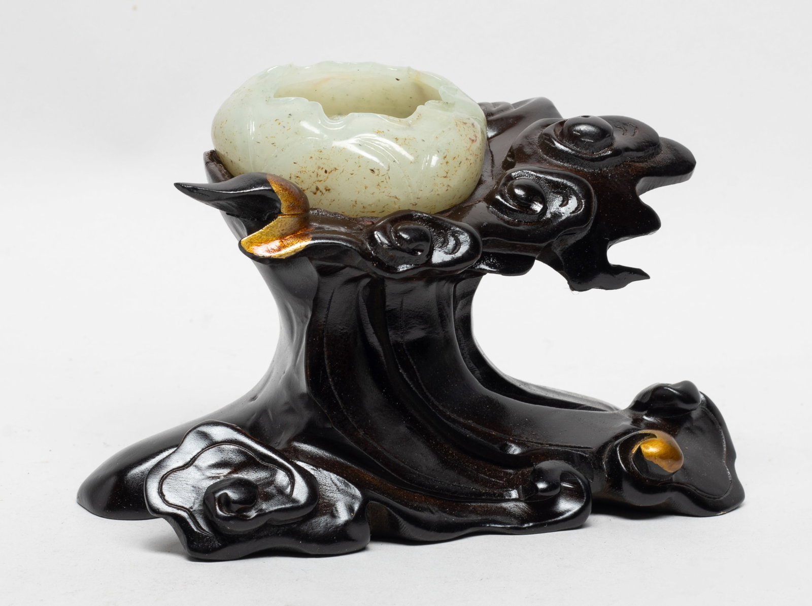 Unusual Chinese Jade Washer on Wood Stand: Chinese russet jade washer naturalistically modelled as a lotus leaf with curled edges, affixed to a wood stand carved of clouds form. Approx. 6.2*3.1*4.2 inch (w/ stand).