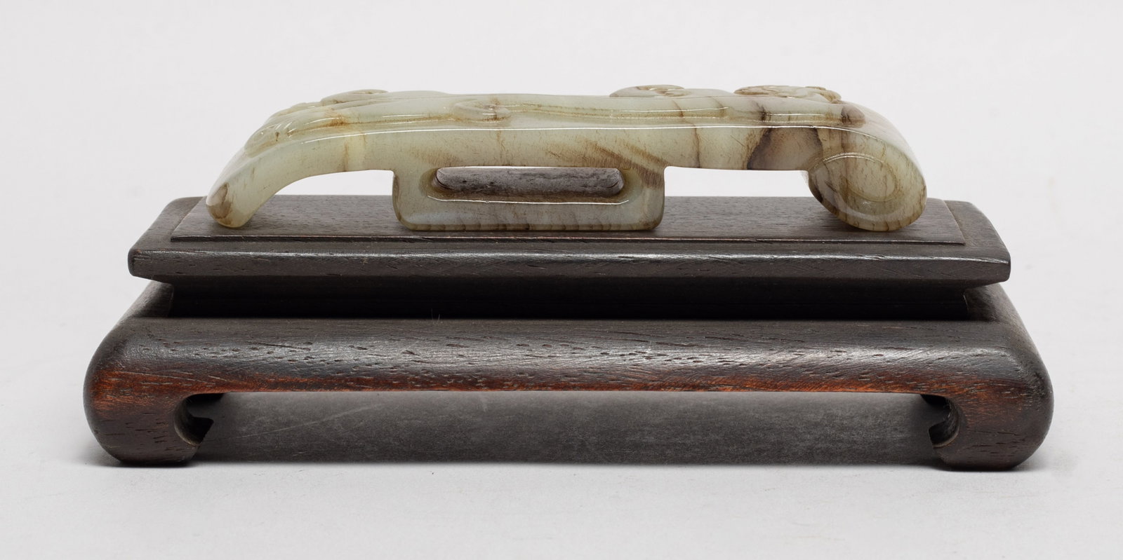Estate Chinese Jade Sword Slide w/ Wood Stand: The russet jade sword slide based on archaistic prototype and carved on the top with a sinuous chi dragon, with stand. Approx. 4.15*1.2*0.7 inch (jade size). The Estate of the Store Closed Sale.