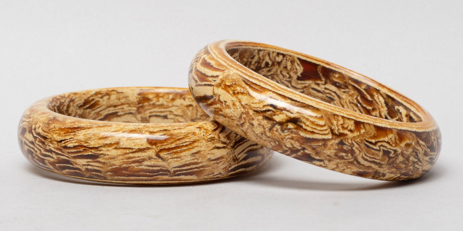 Two Chinese Amber Strong Bangles: Two Chinese amber carved bangles. Approx. 73 gram (total weight), 3.1 inch outer diameter, 2.4 inch inner diameter (each).