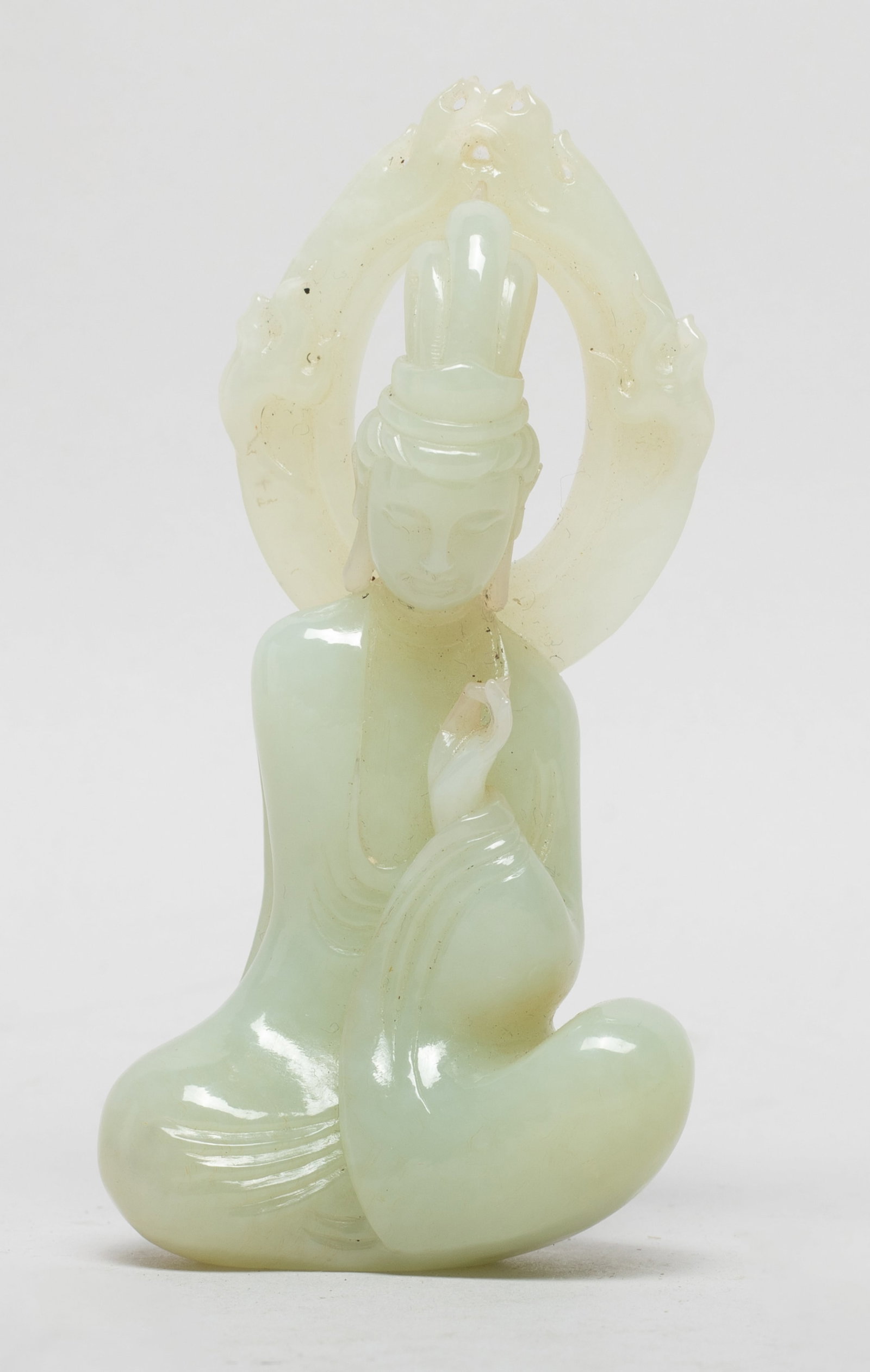 Vtg. Chinese Jade Carved Sculpture of Buddha: Chinese pale celadon jade sculpture carved as seated Buddha, the right hand in Karana mudra, the serene face surmounted with a tall chignon, a flamed mandorla behind his head. Approx. 3.85*1.9*1 inch.